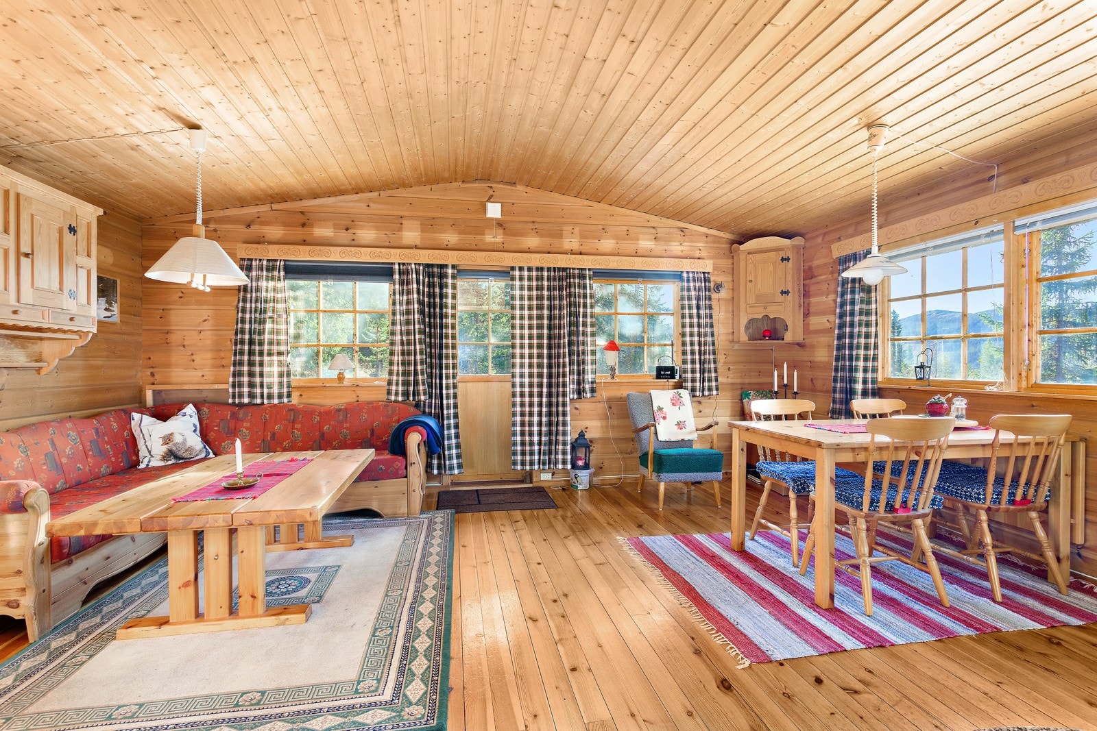 Stue med dør ut til terrassen. Møbler som står igjen i hytta medfølger salget. Galleribilde