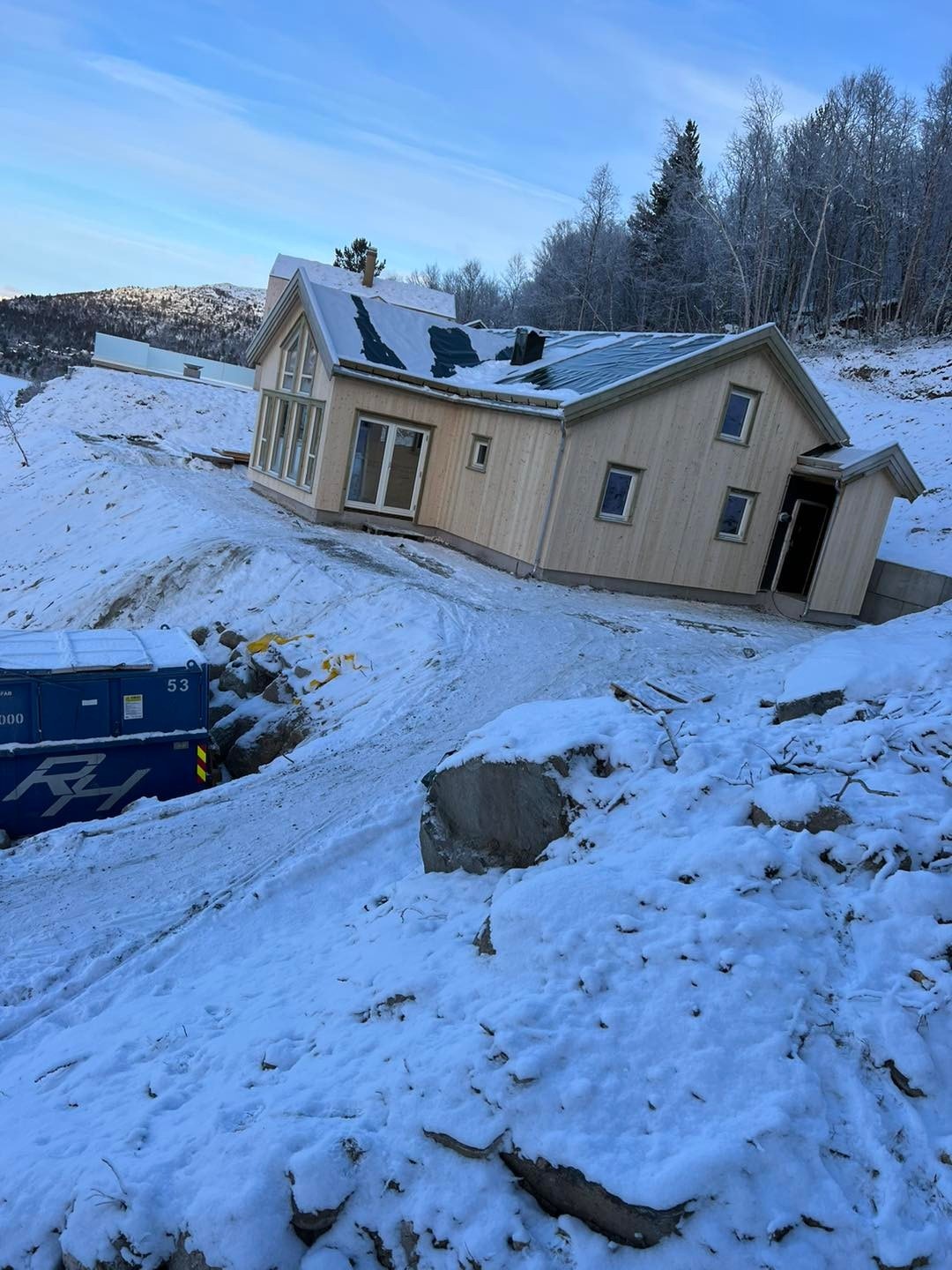 Denne hytten har veldig mye vinduer, og en dobbel dør ut til en skjermet og solrik uteplass.
Bildet er av en solgt hytte under oppføring Galleribilde