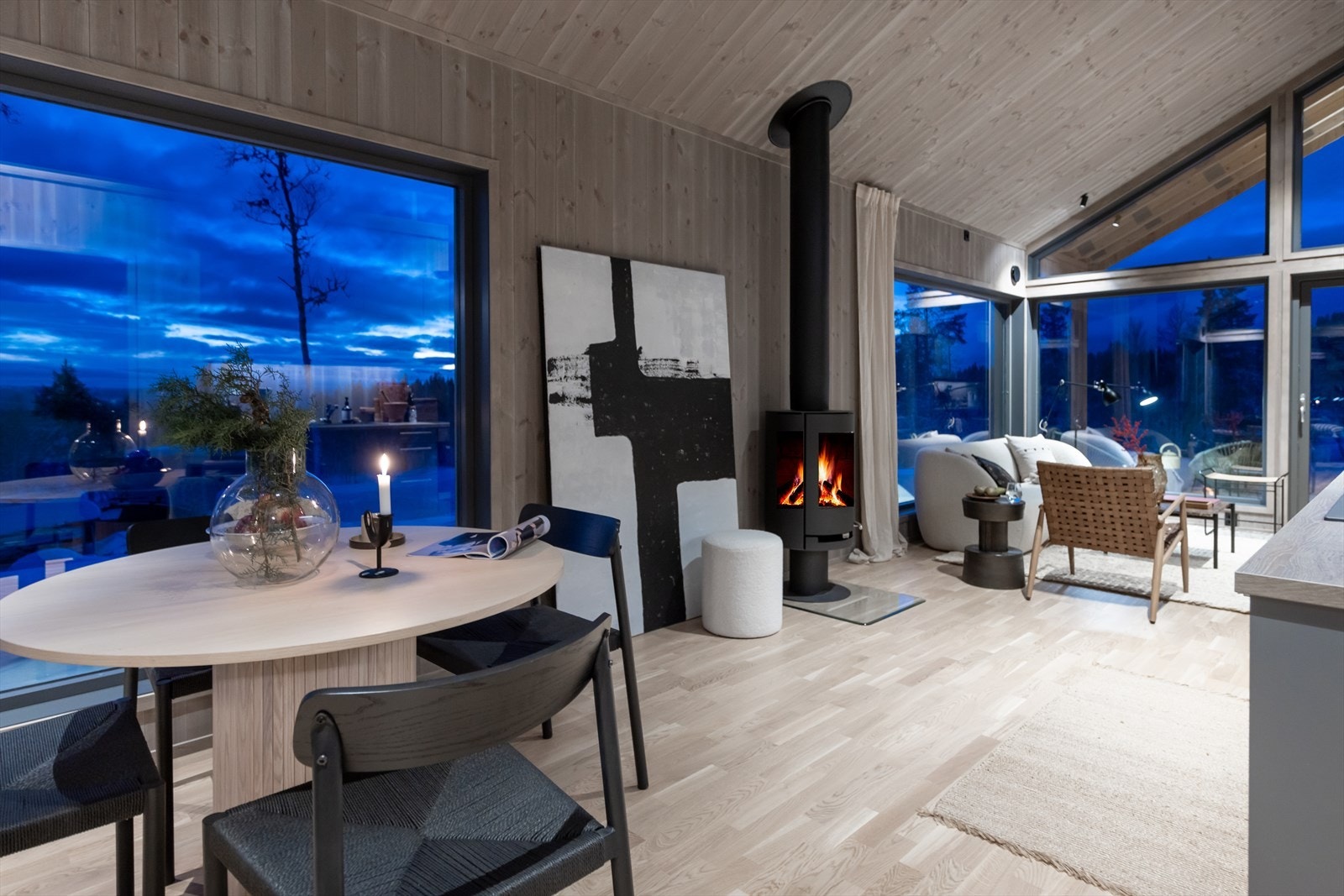 Velkommen inn. Fin moderne peisovn som naturlig deler hytta i to soner. Spisestue og stue Galleribilde