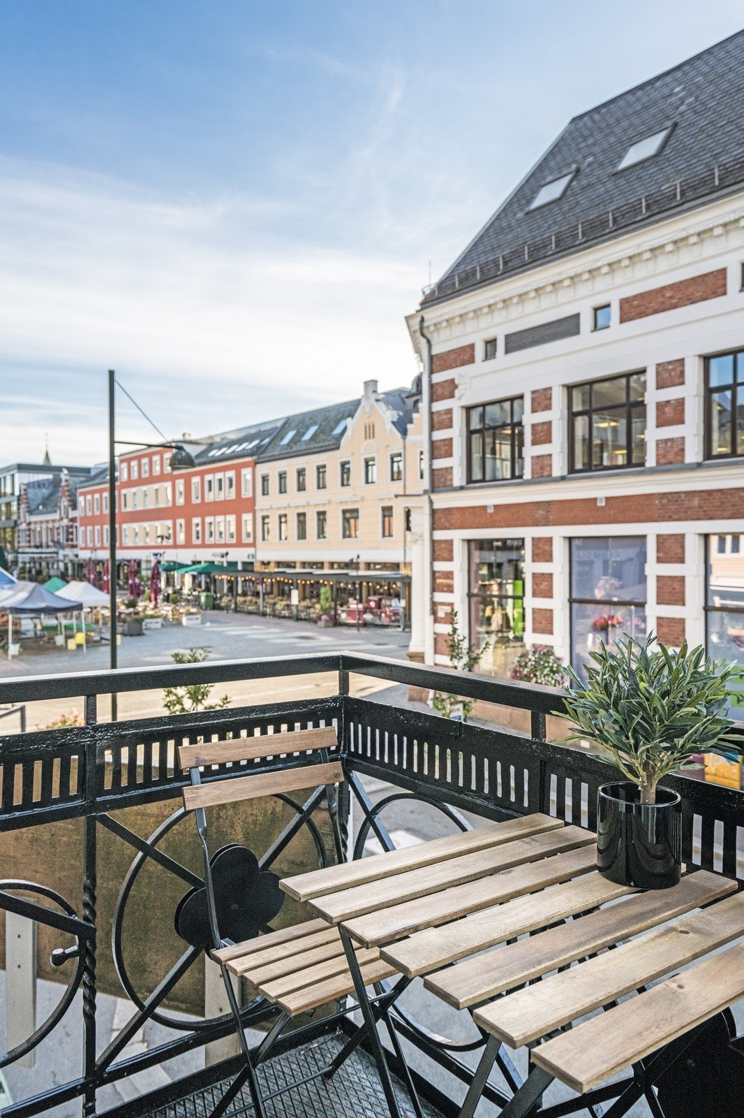 Sydvendt balkong midt i byen med utsikt mot torvet og gågata Galleribilde