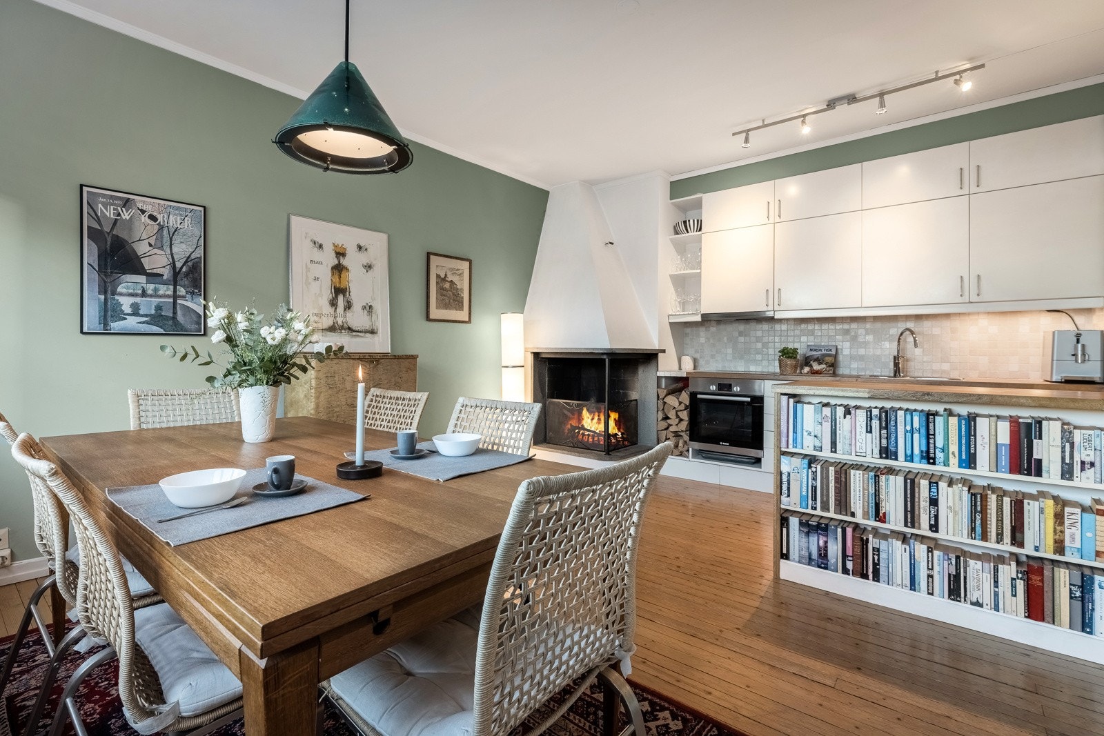 Pent og romslig kjøkken med en funksjonell og hyggelig peis i hjørnet Galleribilde