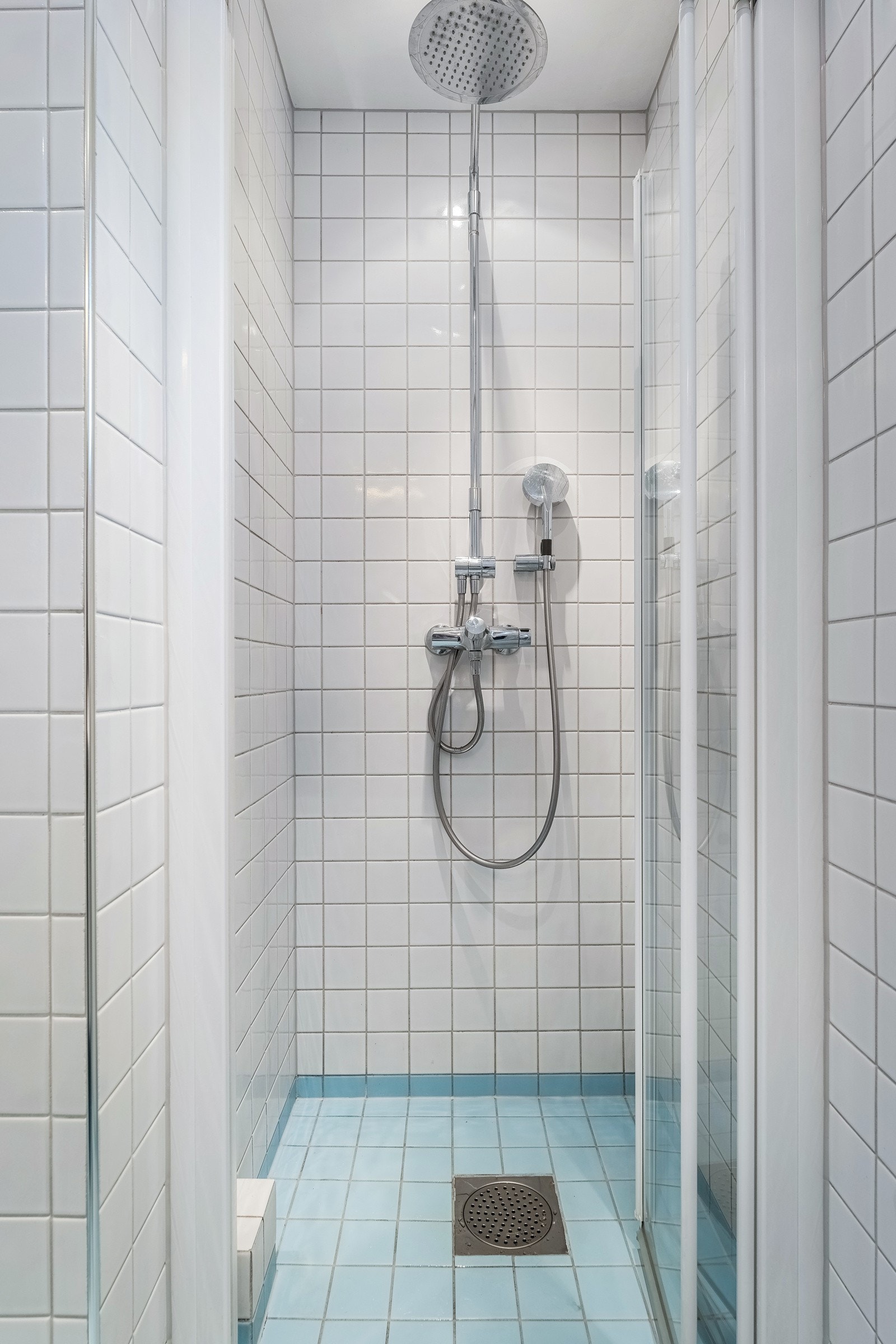 Dusjnisje med både hånd- og regnfallsdusj og foldedører Galleribilde