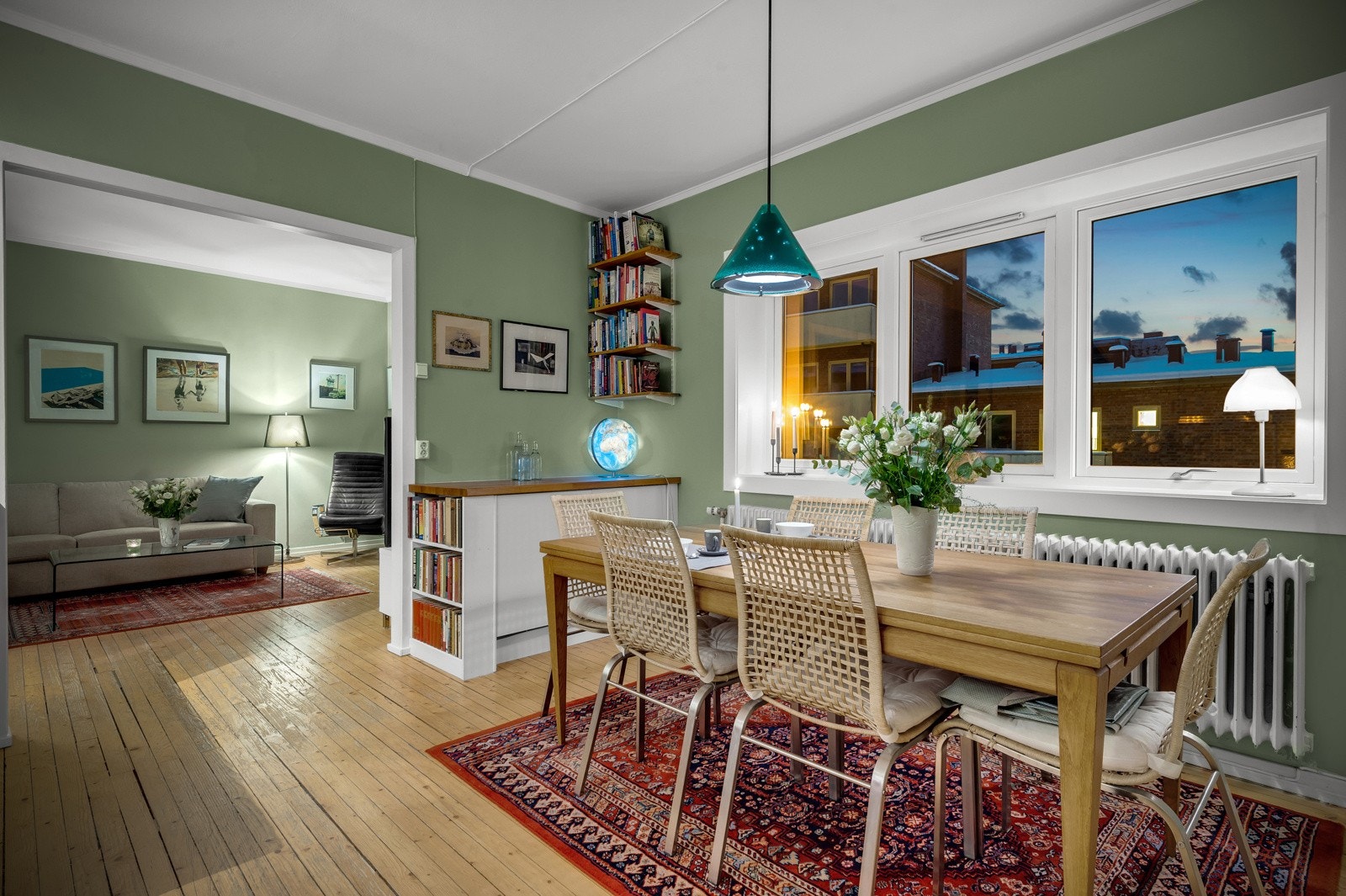 Gjennomgående gulv i heltre fører deg sømløst gjennom stuen og inn på kjøkkenet Galleribilde