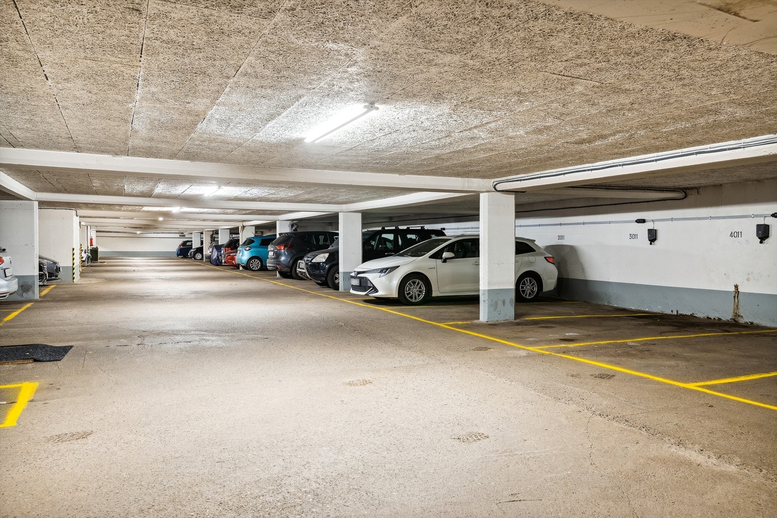 Parkeringsplass med elbillader i underliggende garasjekjeller. Galleribilde