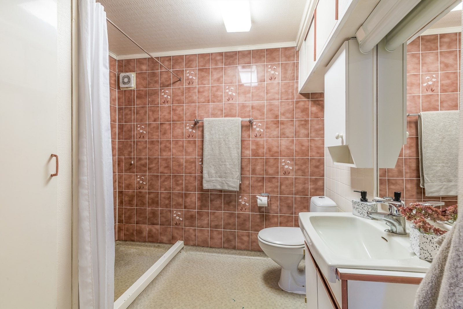 Eldre bad i underetasje med flis på vegg og belegg i gulv Galleribilde