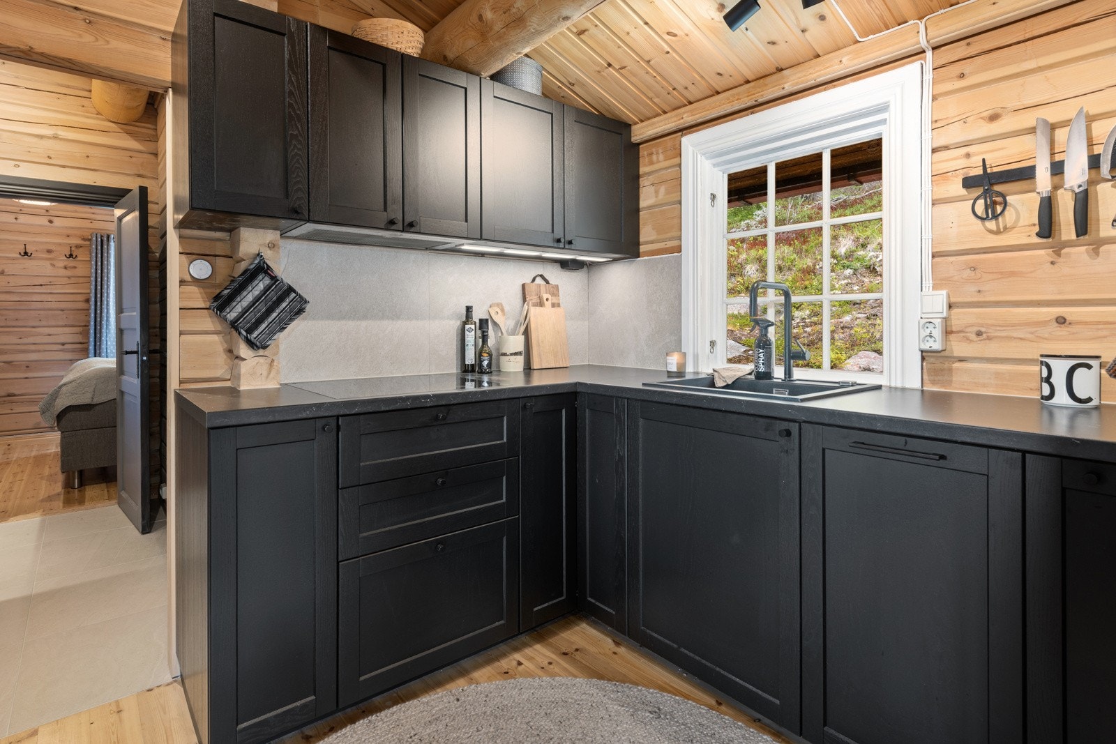 Det er lagt fliser på vegg over benk og montert kjøkkenventilator med kullfilter. Kjøkkenet har integrert platetopp og oppvaskmaskin. Galleribilde