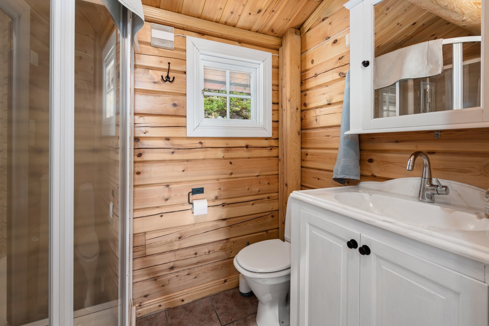 Bad med fliser på gulv og vegger utført med tømmer. Galleribilde