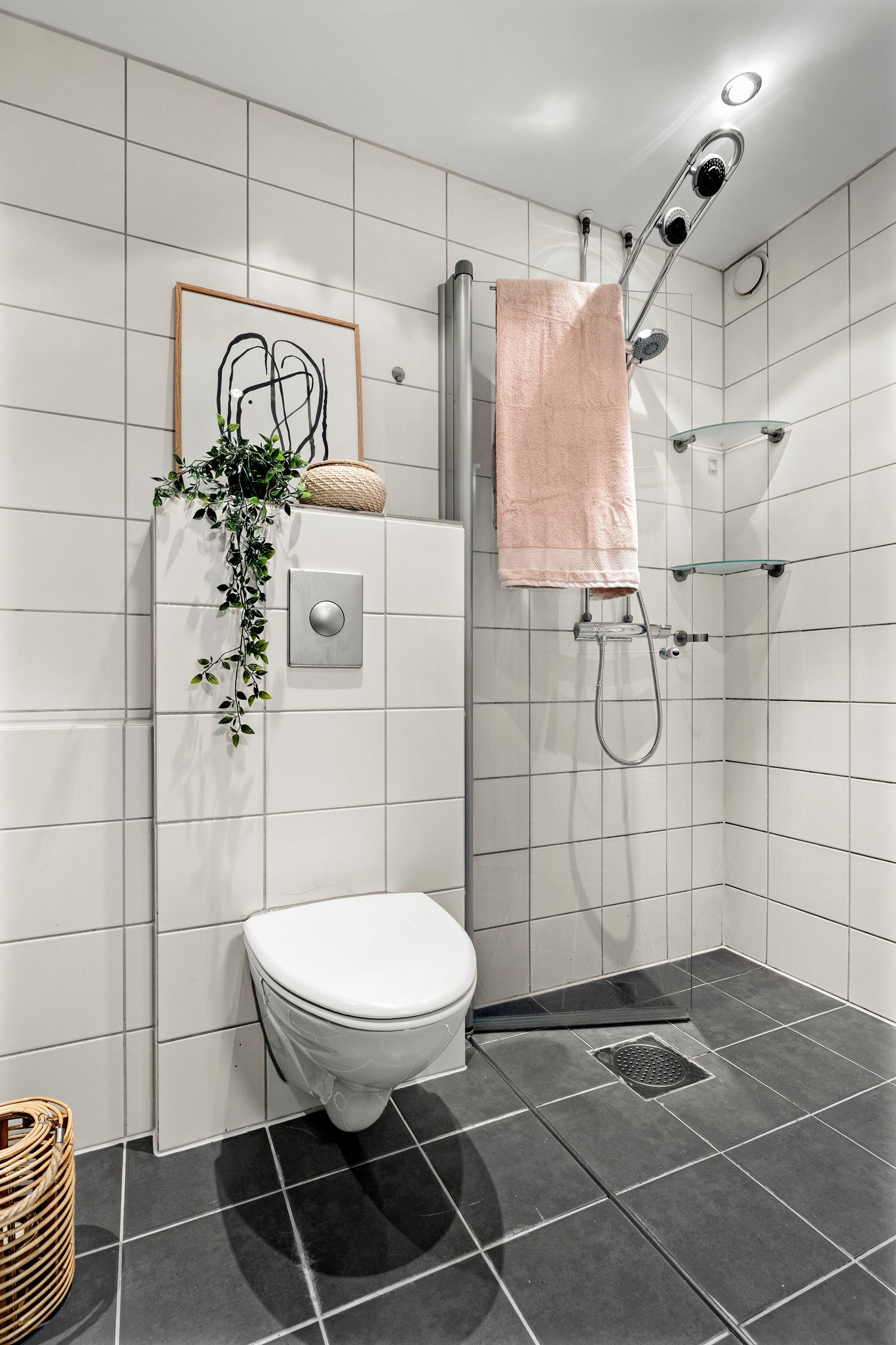 Badet i leiligheten er romslig, og har fliser på veggene, downlights i himlingen og fliser på gulv med gulvvarme Galleribilde