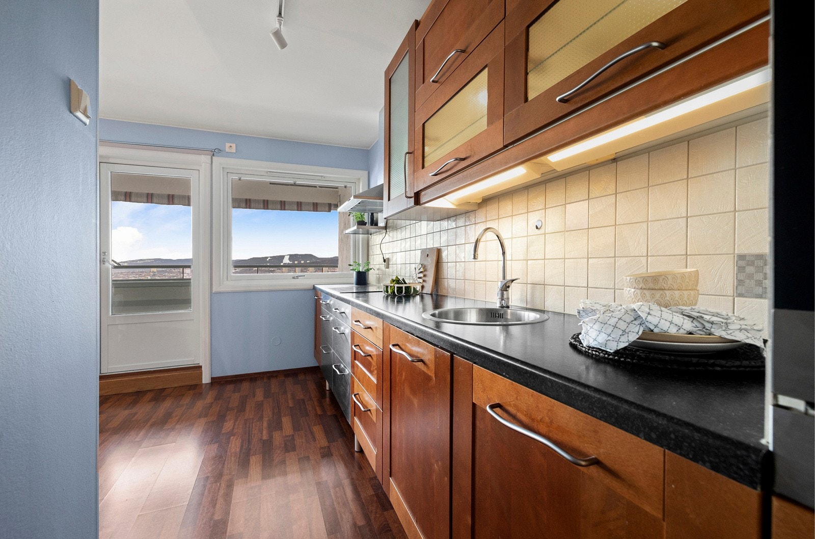 Kjøkkenet har et stilrent design med gode benkeflater og mye oppbevaringsplass Galleribilde