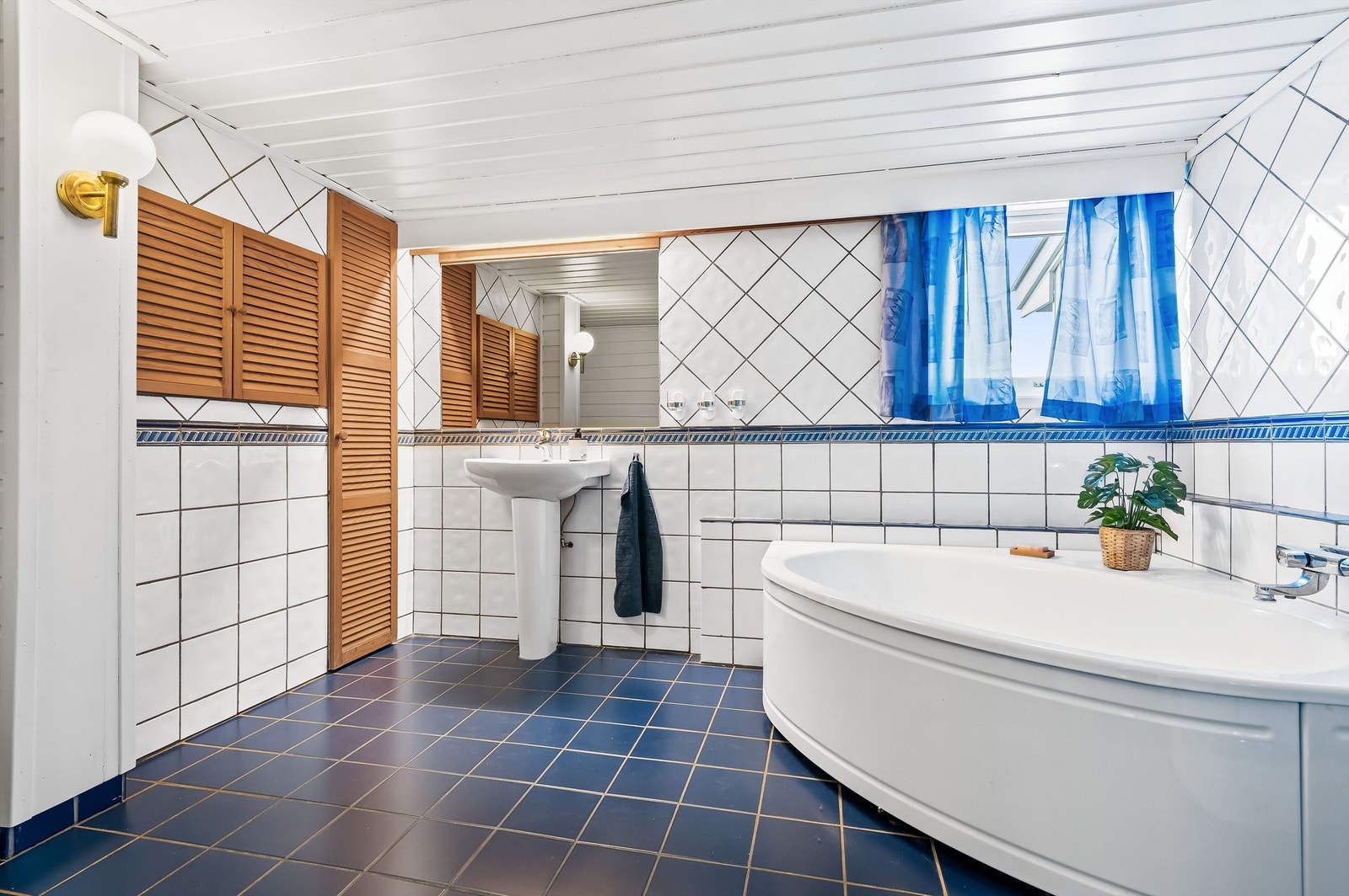 Flislagt bad i 1. etasje med varme i gulvet. Badet er utstyrt med badekar, dusjkabinett, toalett og servant. Galleribilde