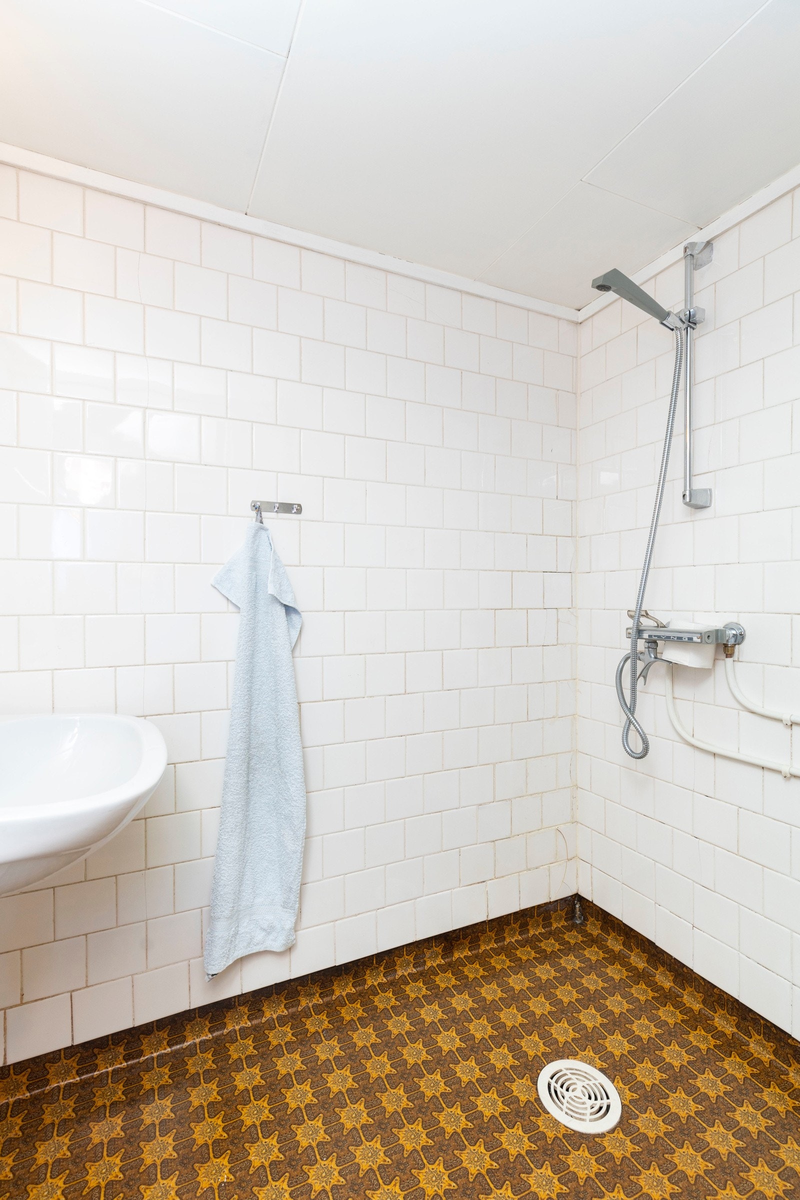 Bad kjeller bestående av servant og dusjinnredning. Belegg på gulv. Galleribilde