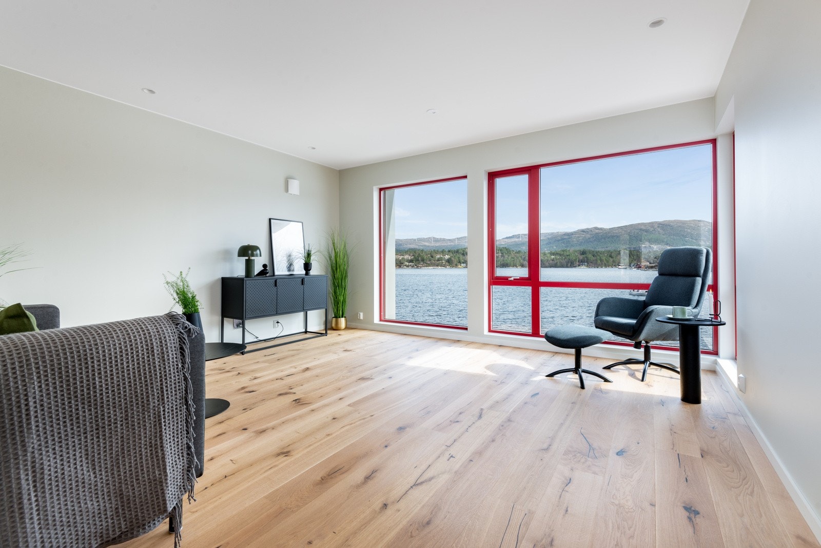 Det er store vindaugsflater med utsikt mot sjøen i front av bygget, som gir ein god romfølelse med mykje lys og ei fantastisk utsikt. Bilete frå Strandhus 2 Galleribilde