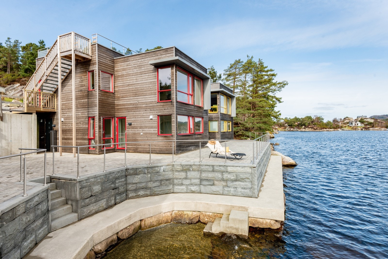 På framsida av strandhuset eig ein fram til gjerdet. Platået nedanfor er laga slik at ein kan gå forbi eigedommen iht. almennsretten. Bilete frå Strandhus 2 Galleribilde