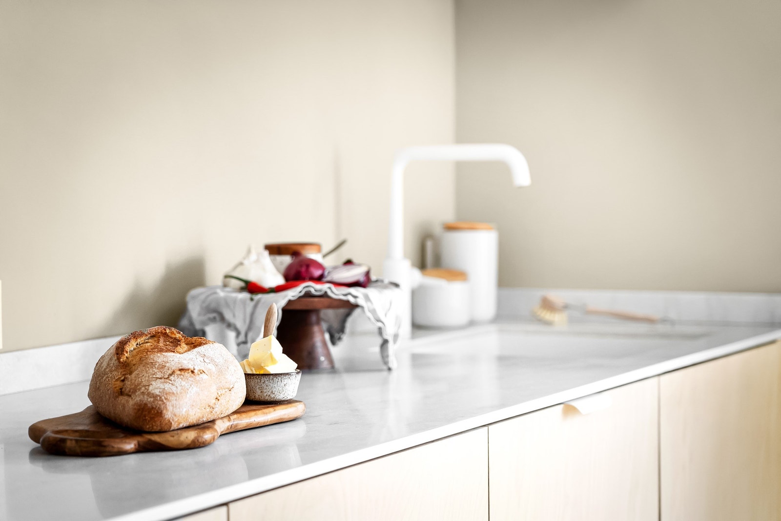 Kjøkkeninnredningen har slette fronter og lyse benkeplater av kompositt fra Corian. Underlimt oppvaskkum med ettgreps armatur i hvitt. Det hvite går også igjen i den integrerte stekeovnen. Galleribilde