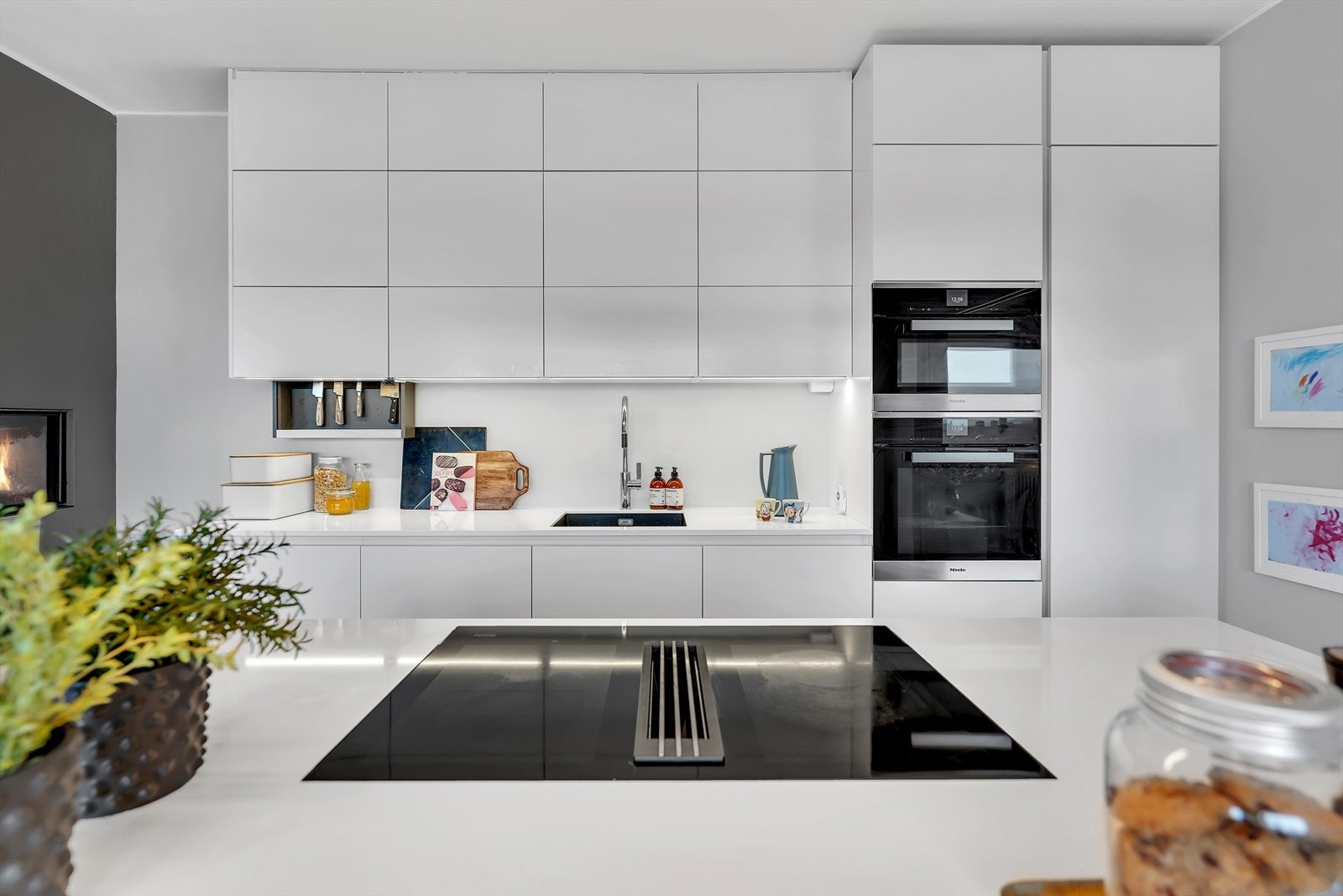Moderne innredning fra HTH (2019) med hvite fronter, gripetak, soft-push og komposittstein benkeplate. Galleribilde