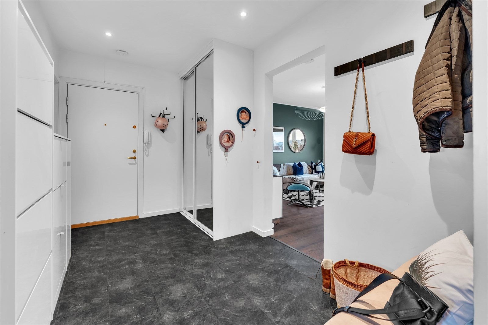 Romslig og innbydende entré med skyvedørsgarderobe og oppbevaring. Galleribilde