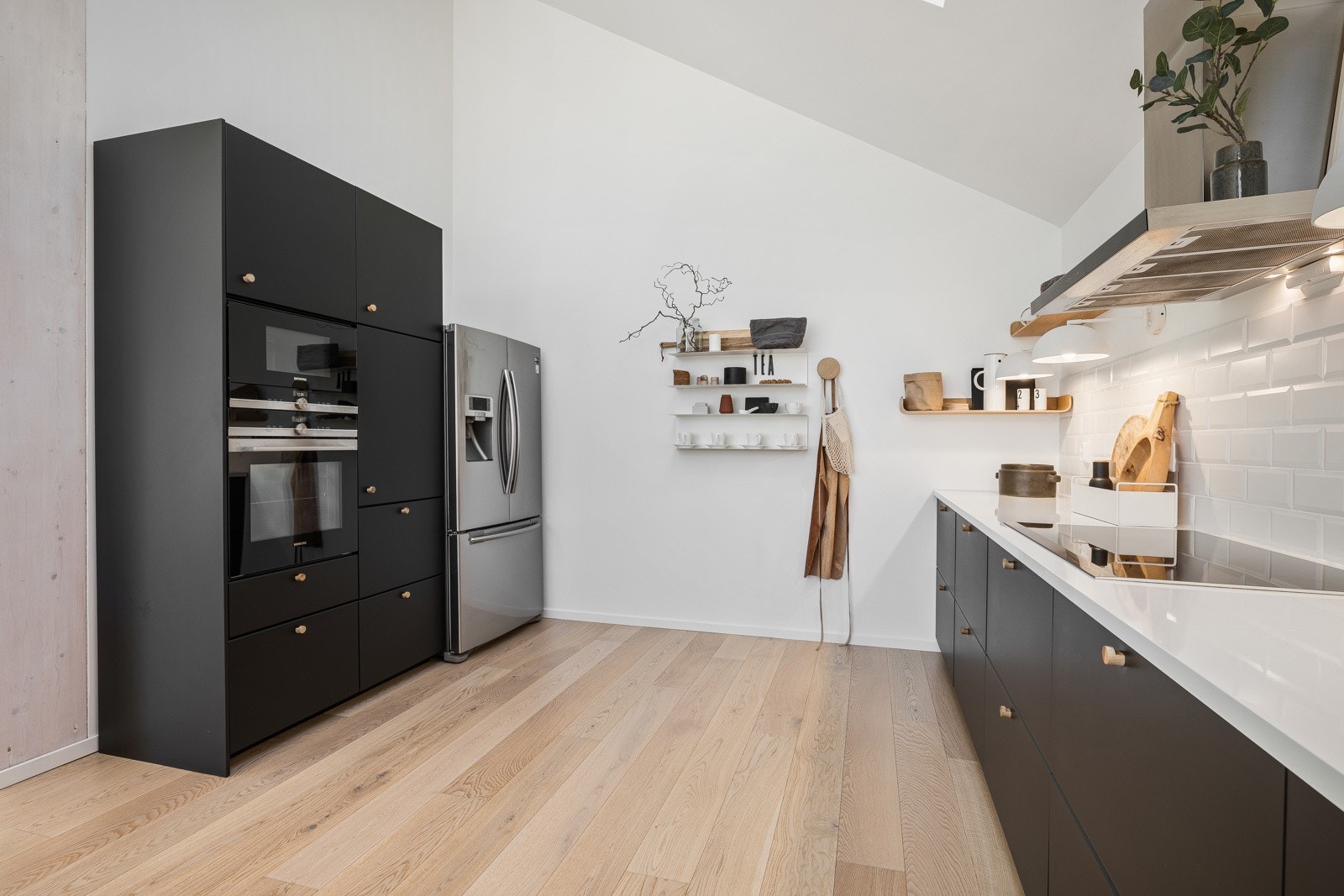 Både induksjonstopp, stekeovn, mikrobølgeovn og oppvaskmaskin er integrert i innredningen. I tillegg er det plass for stort kjøleskap Galleribilde