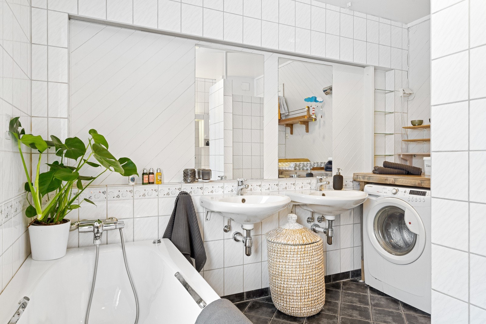 Badet er blant annet ustyrt med badekar, dusjhjørne med kabinett, opplegg for vaskemaskin og varmekabler i gulv Galleribilde