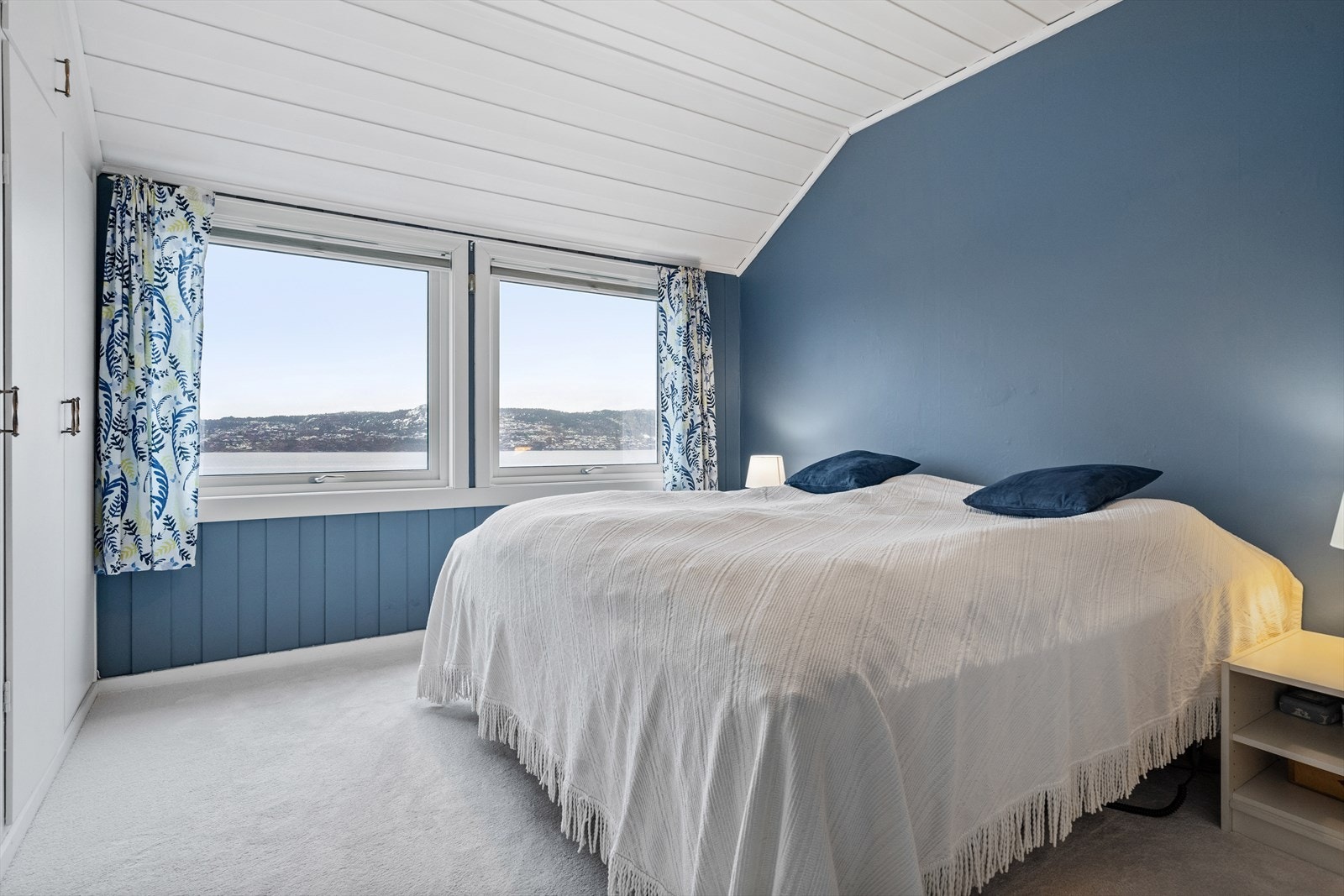 Hovedsoverommet har plassbygde skap og teppe på gulv. Galleribilde