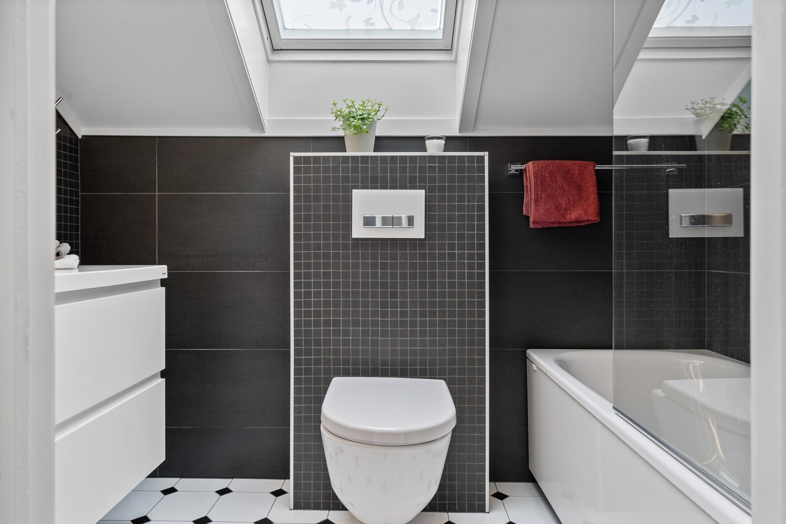 Bad er innredet med vegghengt wc, servant med møblement og badekar med dusj. Galleribilde