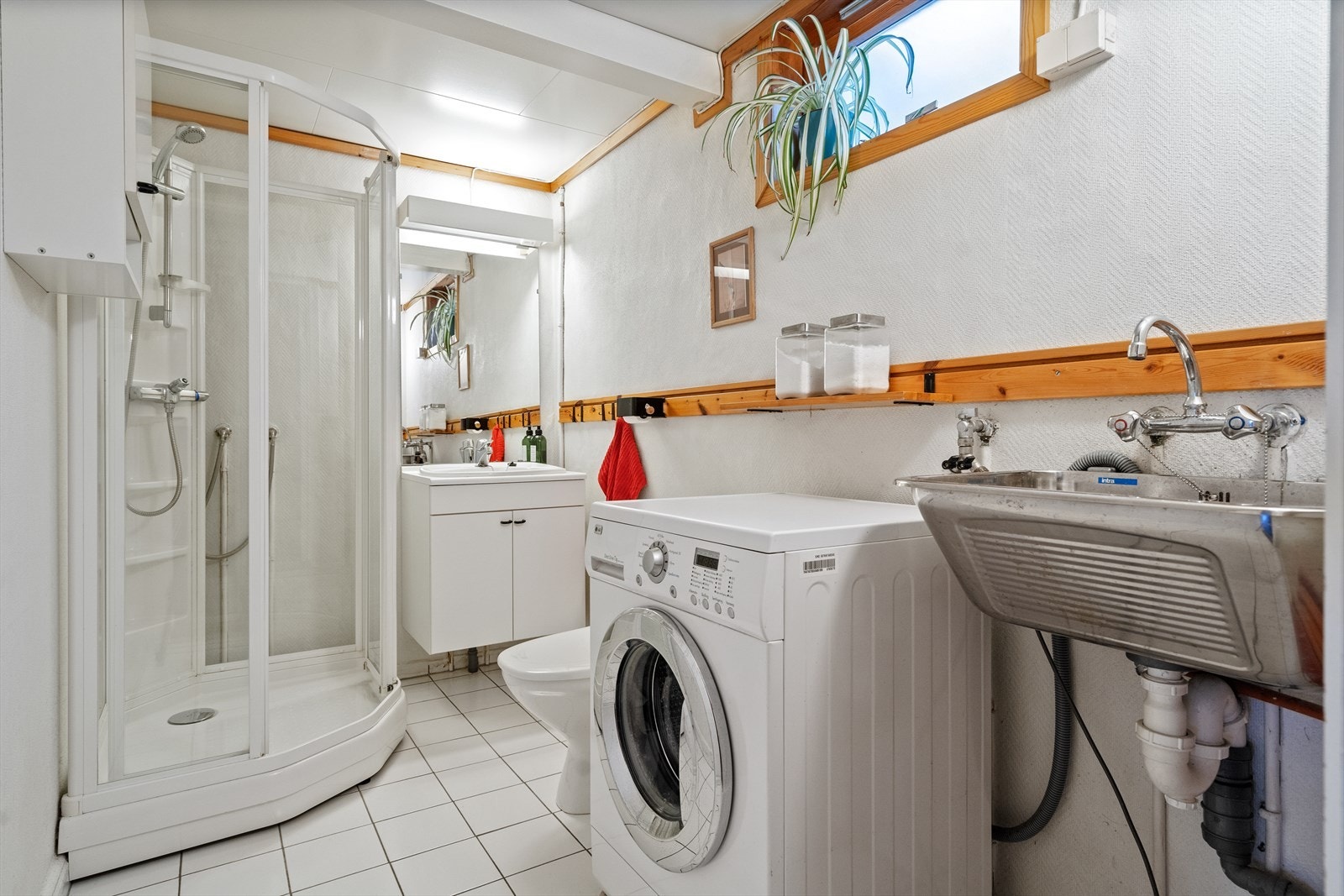 Eldre bad i underetasjen med skyllekar og opplegg for vaskemaskin. Galleribilde