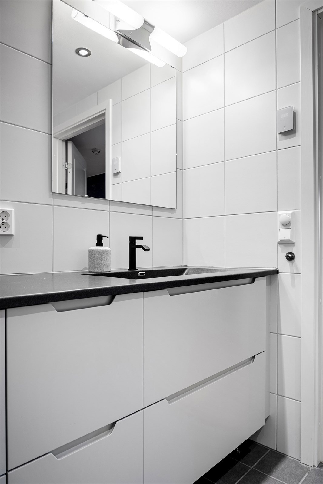 Badet er innredet med servant på benkeplate som strekker seg fra vegg til vegg som gir et pent og ryddig inntrykk. Galleribilde