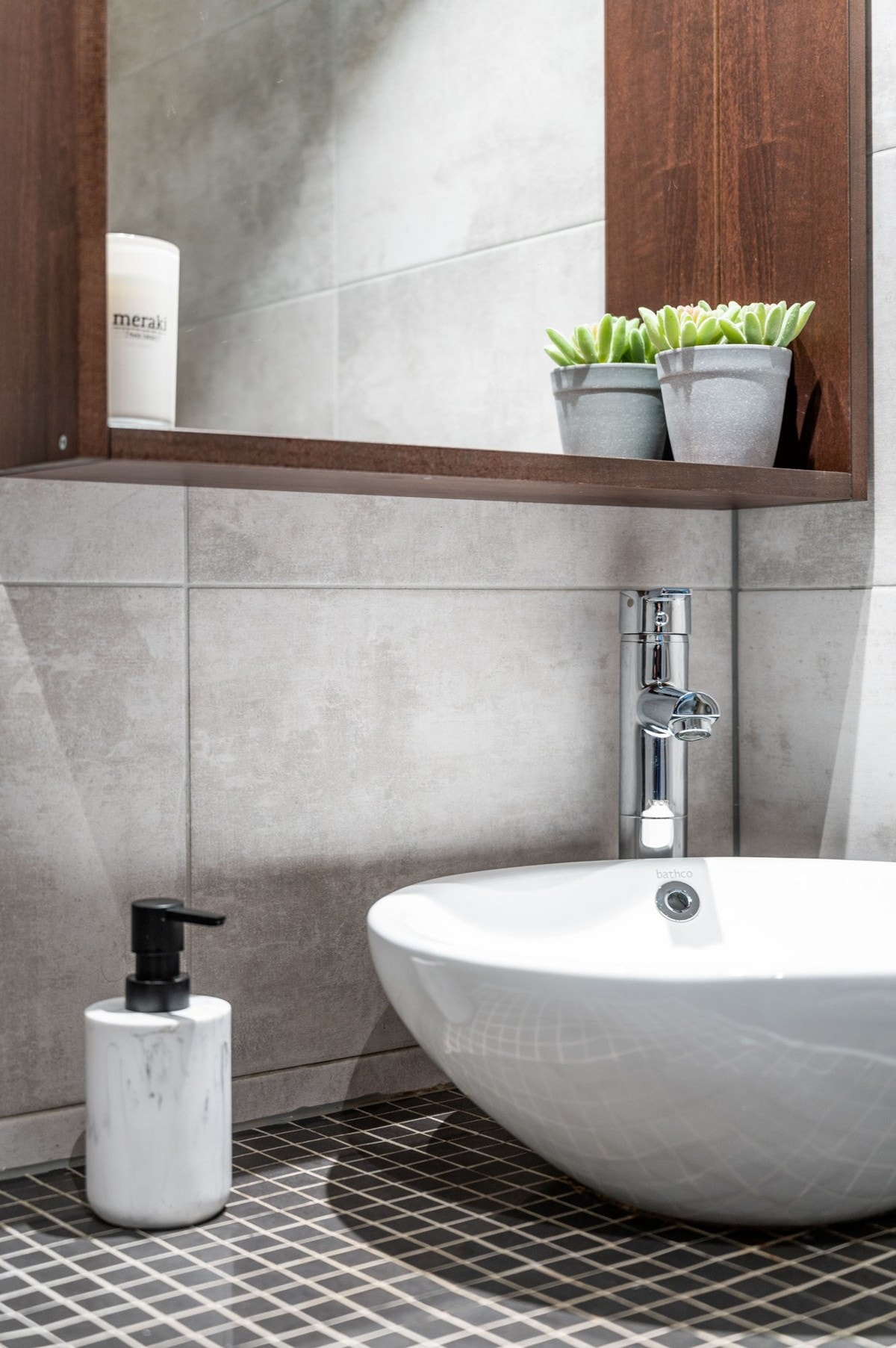 Flott flislagt baderomsinnredning med ovenpåliggende bolleservant og speil med belysning over. Baderommet er også utstyrt med dusjhjørne med innfellbar glassdør og både hånd- og regnfallsdusj, samt vegghengt toalett. Galleribilde