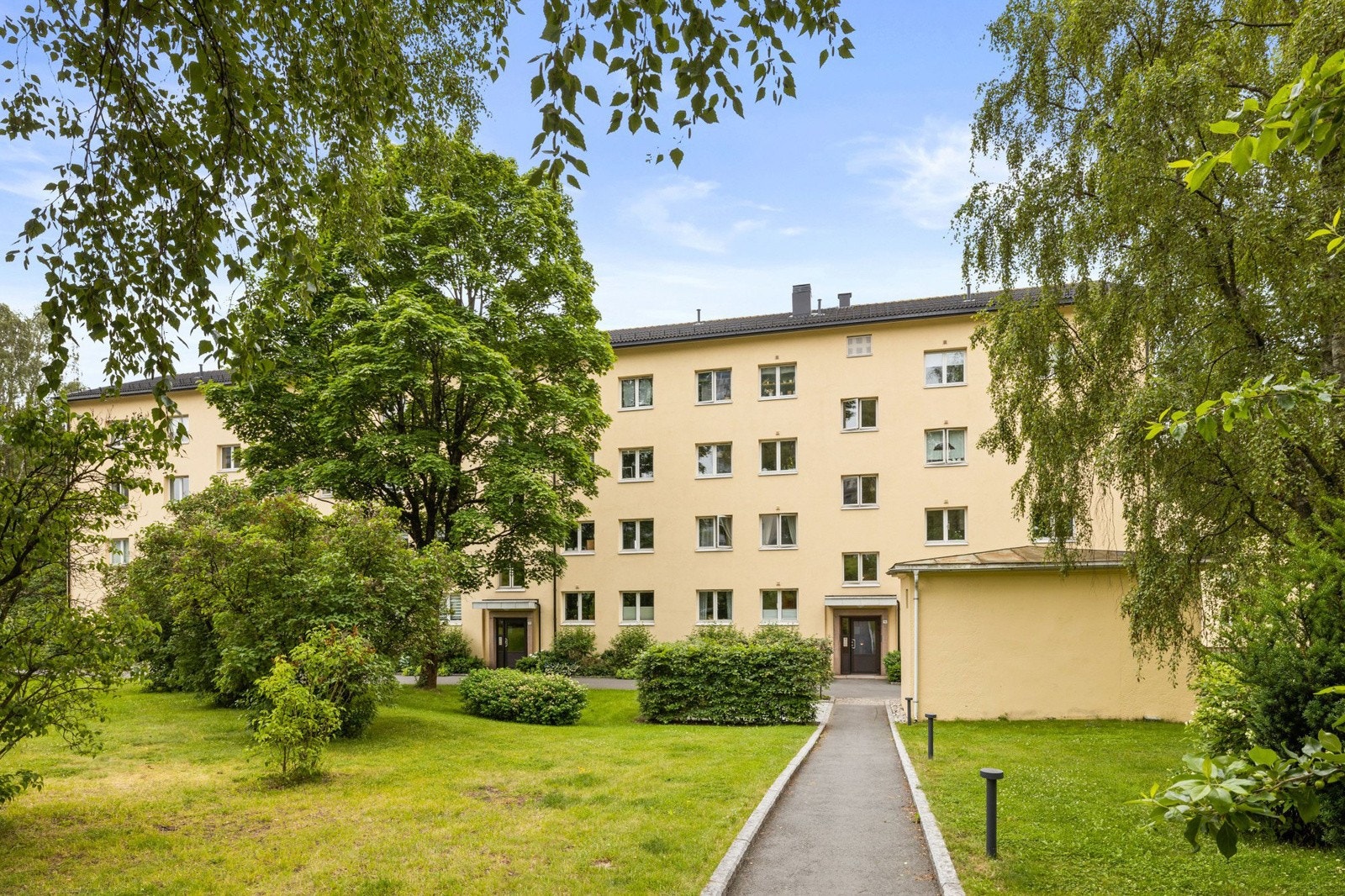 Tomten er skrånende og delvis inngjerdet, med flotte velholdte gressplener mellom bebyggelsen. Galleribilde