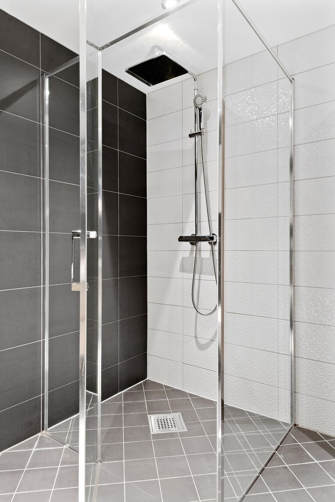 Baderommet er godt utstyrt med dobbeltservant, speil- og veggskap samt dusjhjørne med regnfallsdusj Galleribilde