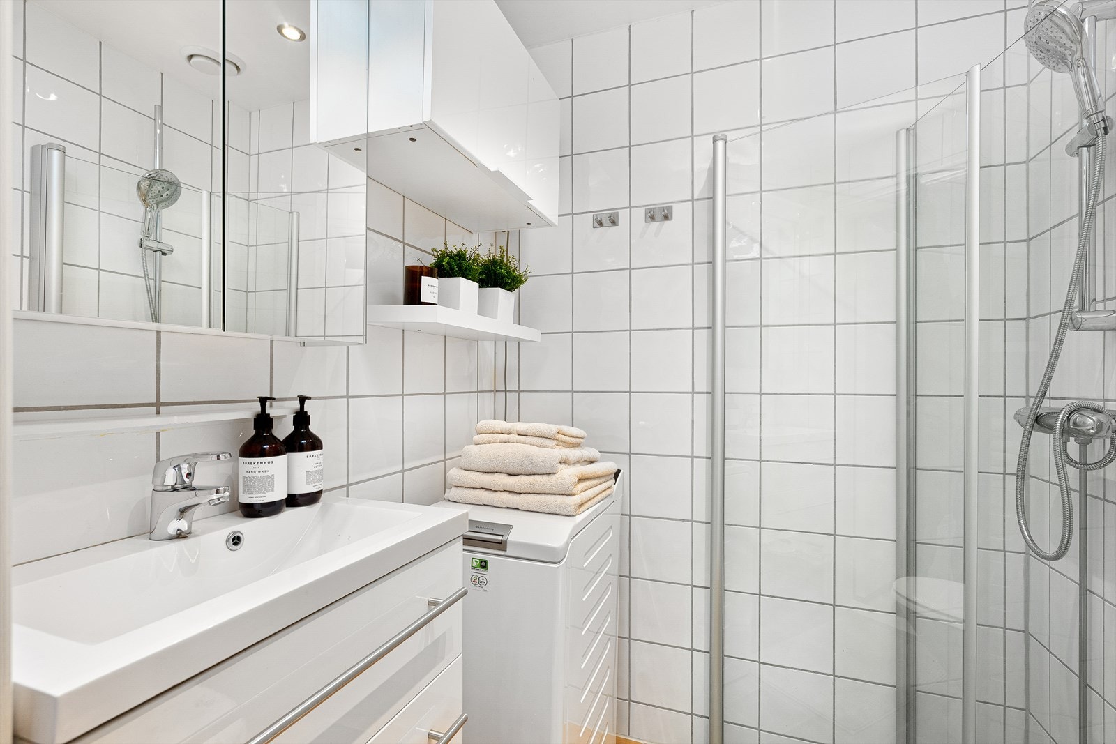 Badet har servant med ett-greps armatur og speilskap med belysning og stikkontakt. Galleribilde