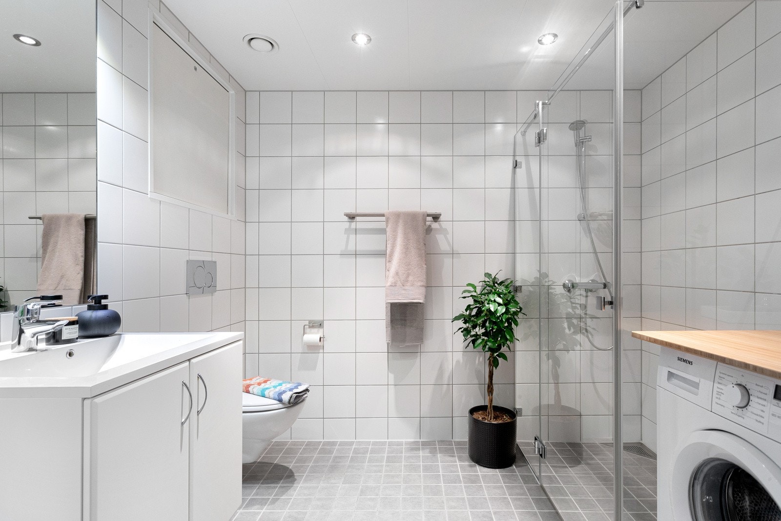 Baderom fra byggeår 2014. Badet har en god størrelse, tidløse fliser på overflater og varme i gulv. Galleribilde