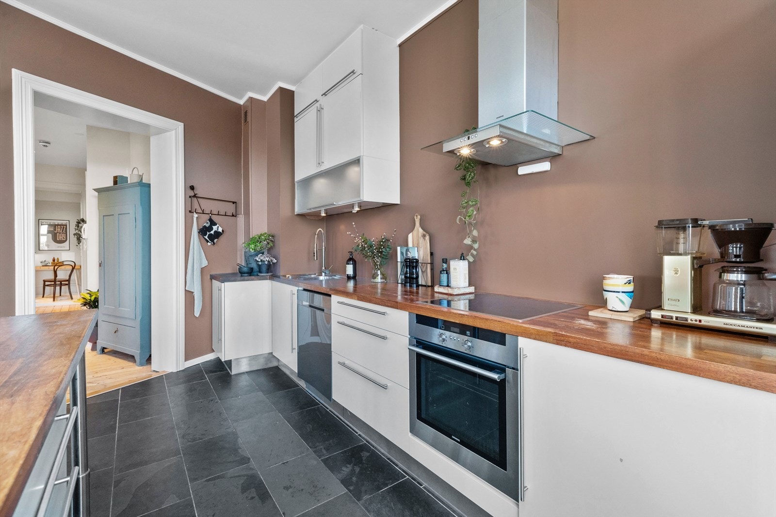 Det er benkebelysning og over kokesonen er det avtrekksvifte i børstet stål. Galleribilde