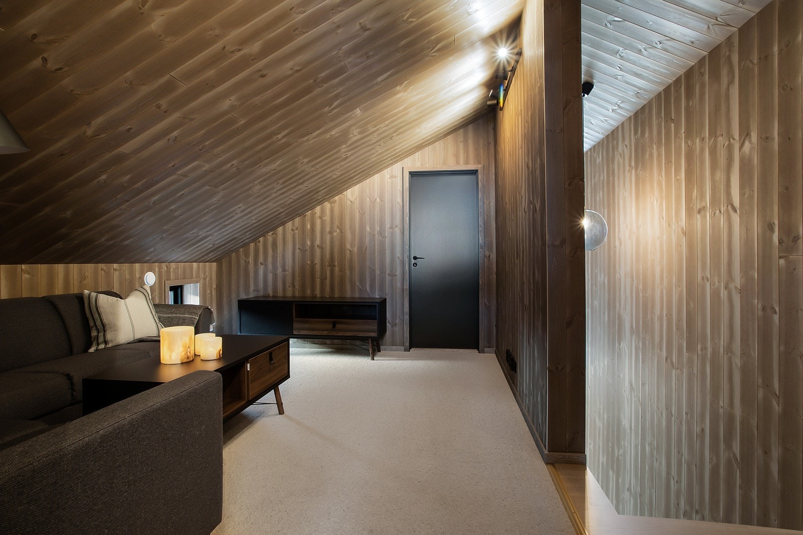 Loftstuen har teppe på gulv som skaper en lun atmosfære. Galleribilde