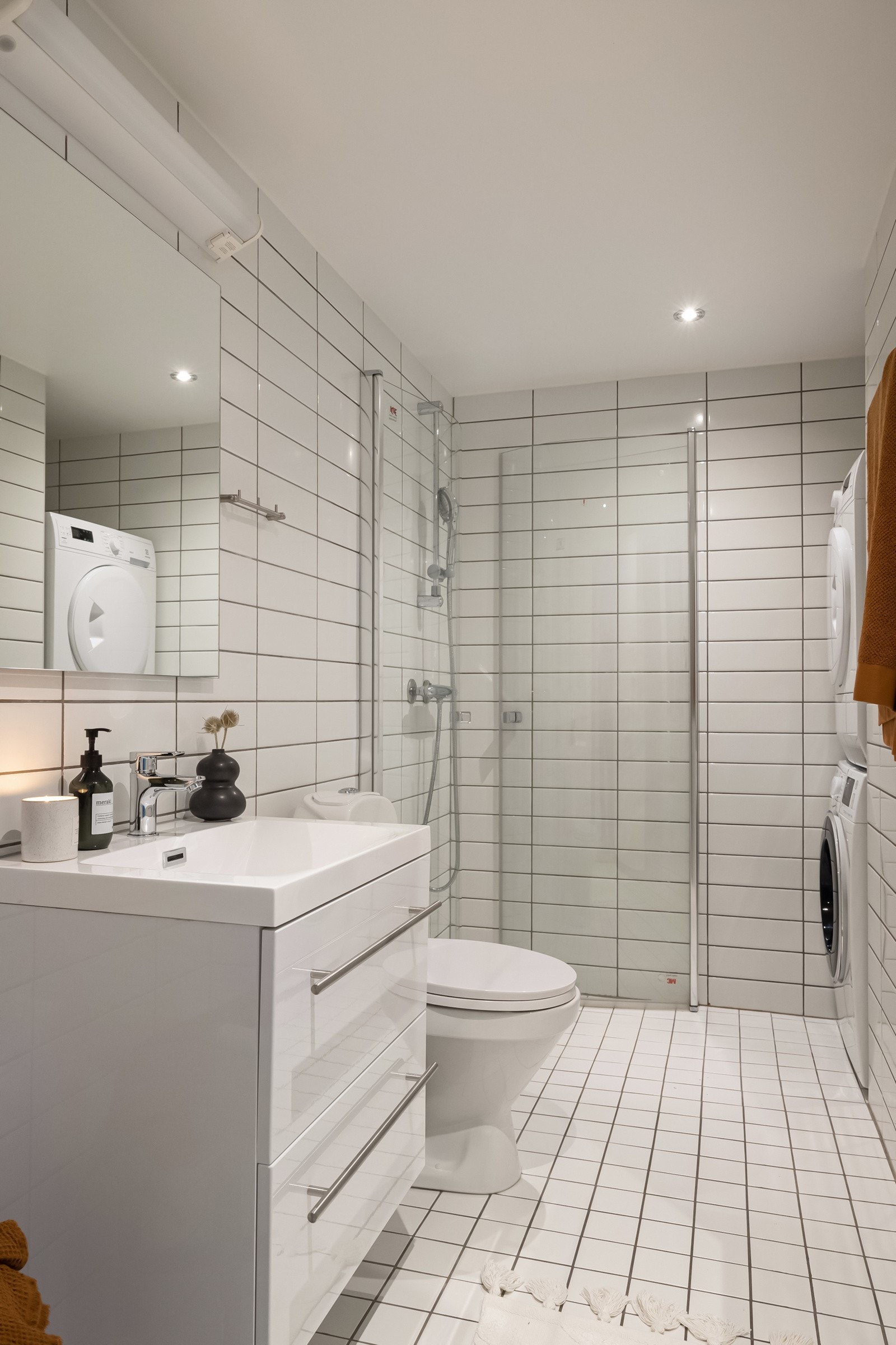 Pent flislagt bad med varme i gulvstøp. Hånddusj med dør i herdet glass og sluk i rustfritt stål Galleribilde