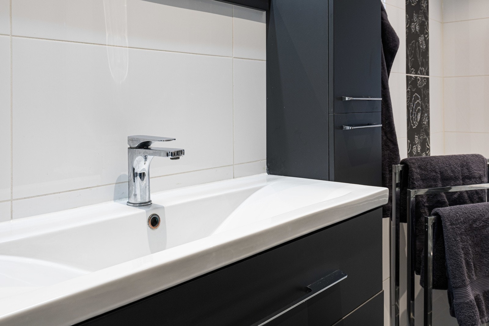 Innredningen består av heldekkende servant, sort skuffeseksjon, matchende høyskap og speil med lys. Galleribilde