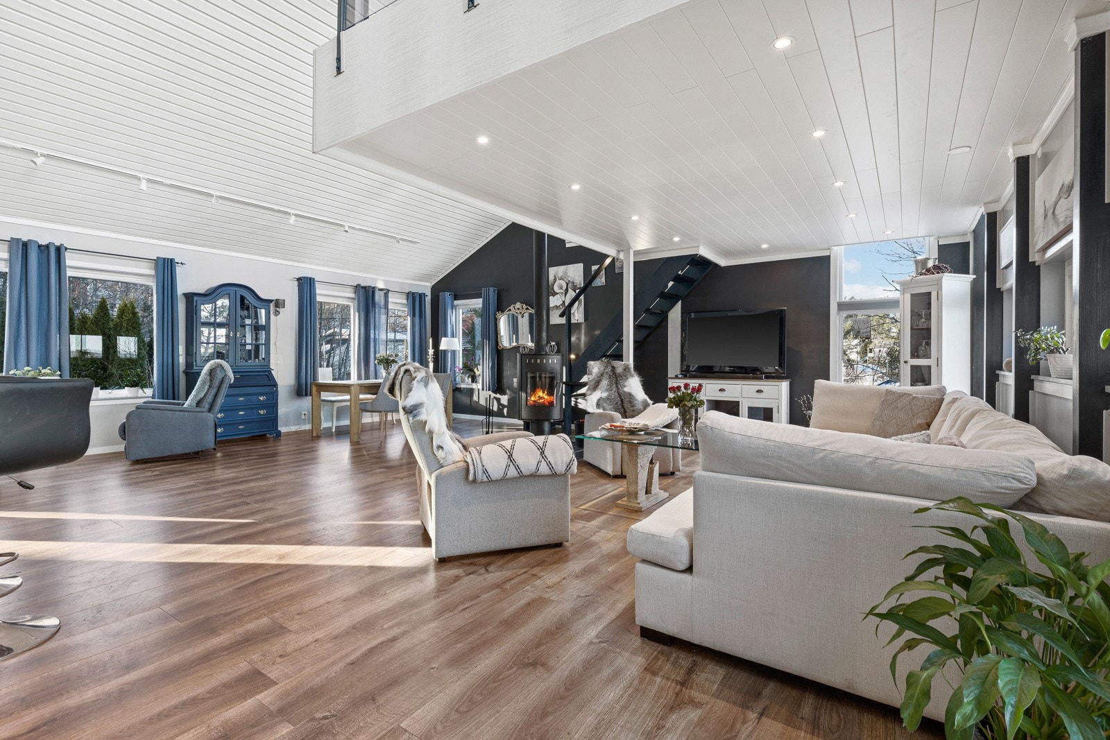 I rommet er det også moderne peisovn som varmer godt, parkettlaminat på gulv med vannbåren gulvvarme og adkomst til innglasset terrasse. Galleribilde