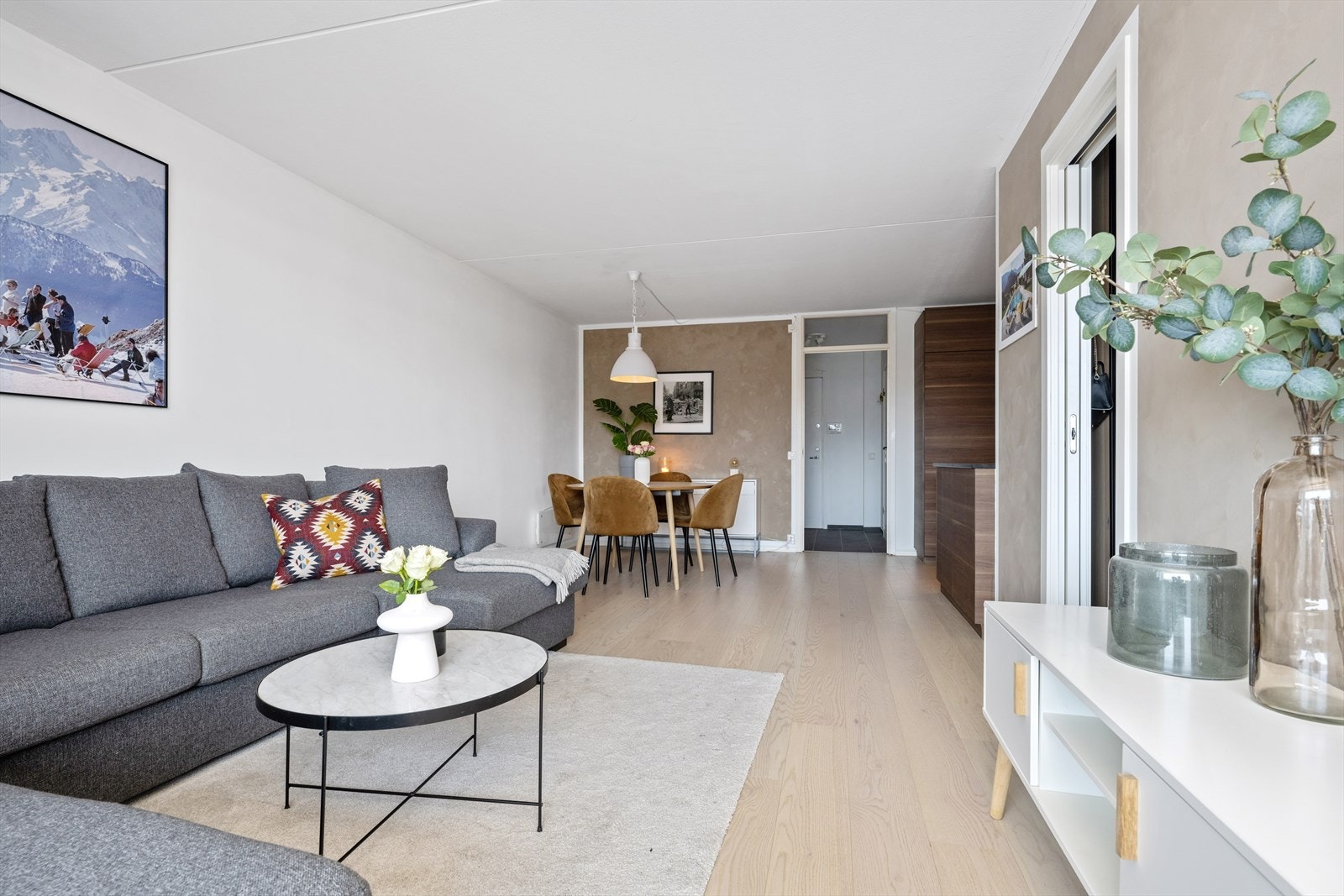 Stuen blir et sosialt rom med en åpen løsning til kjøkkenet. Her er det én-stavs parkett på gulvet og et moderne fargevalg på vegger. Galleribilde