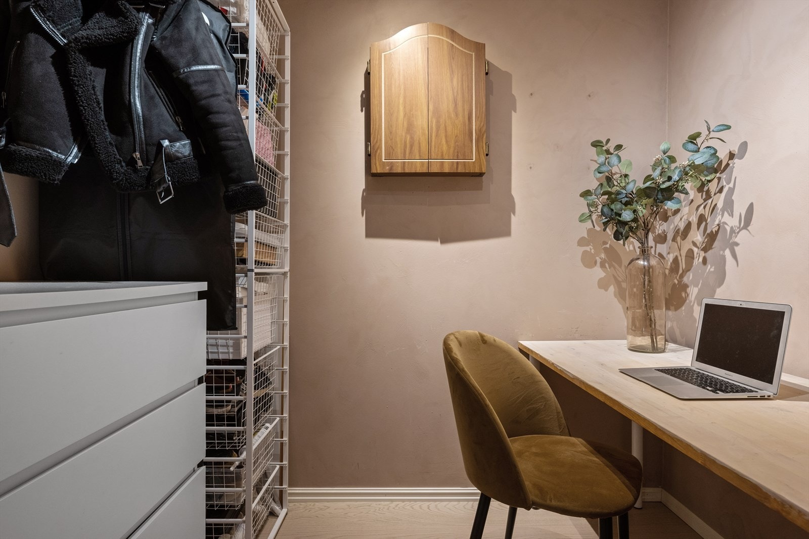 I entréen er det en bod som er oppgradert med parkett og to lufteluker for bedre ventilasjon. Boden er delvis innredet som kontor og garderobe. Galleribilde