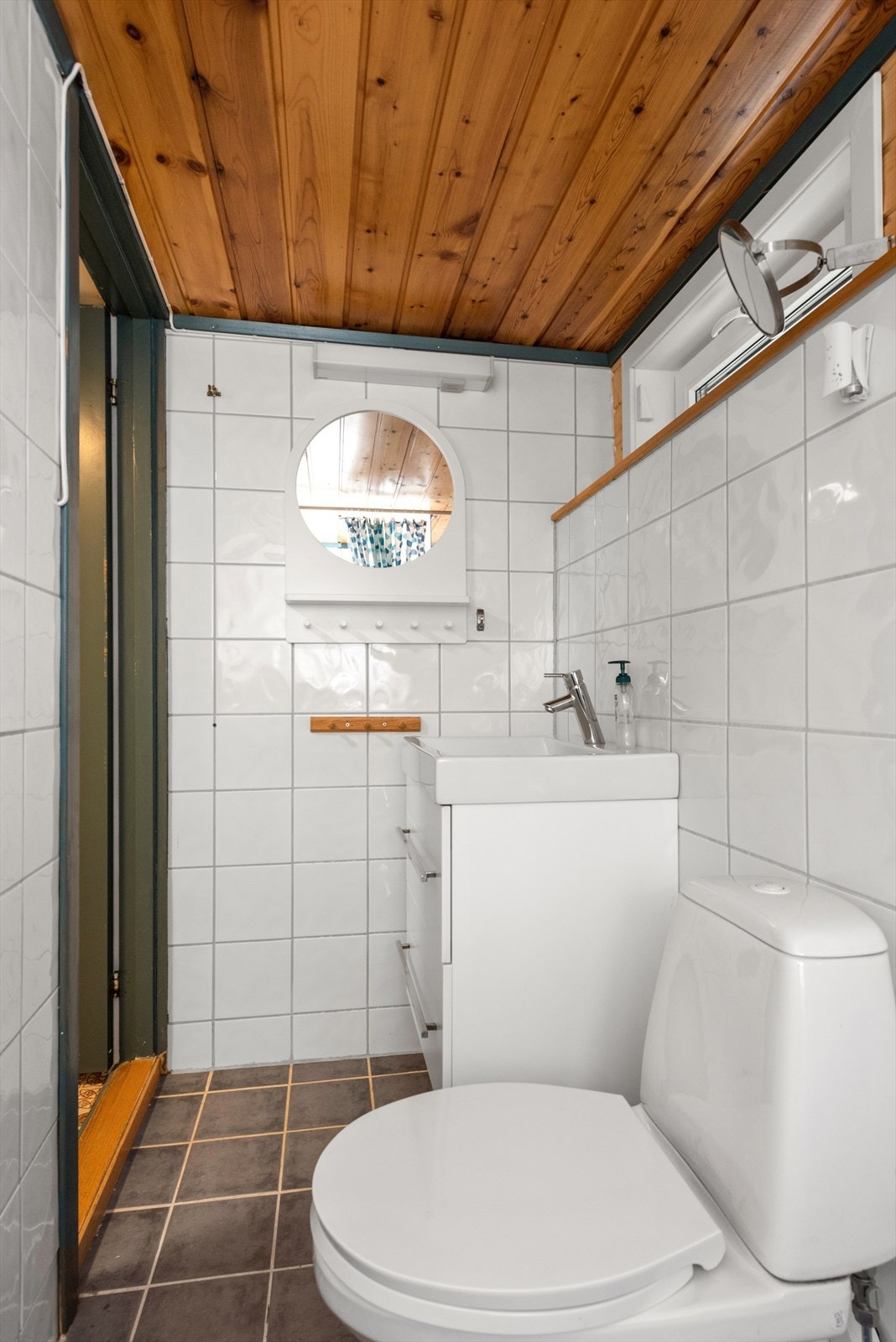 Baderommet har dusj, toalett og servantinnredning med skuffer Galleribilde