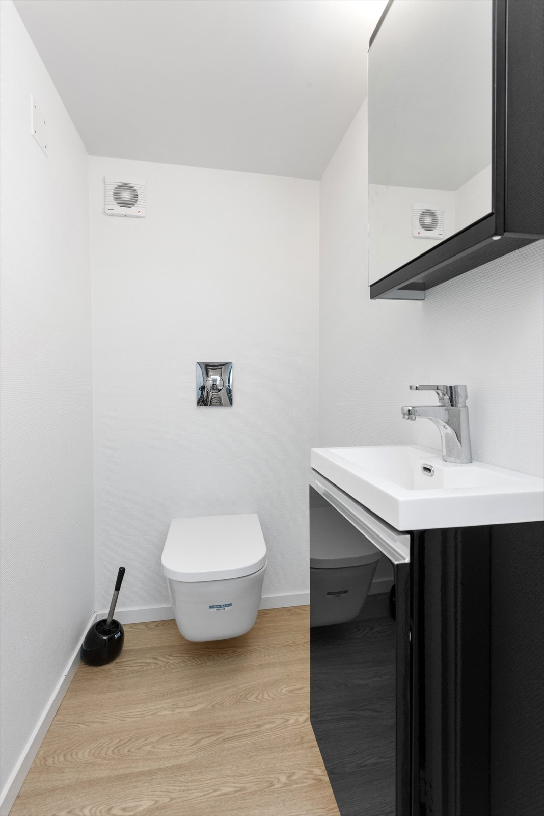 Toalettrom med veggmontert toalett og servant Galleribilde