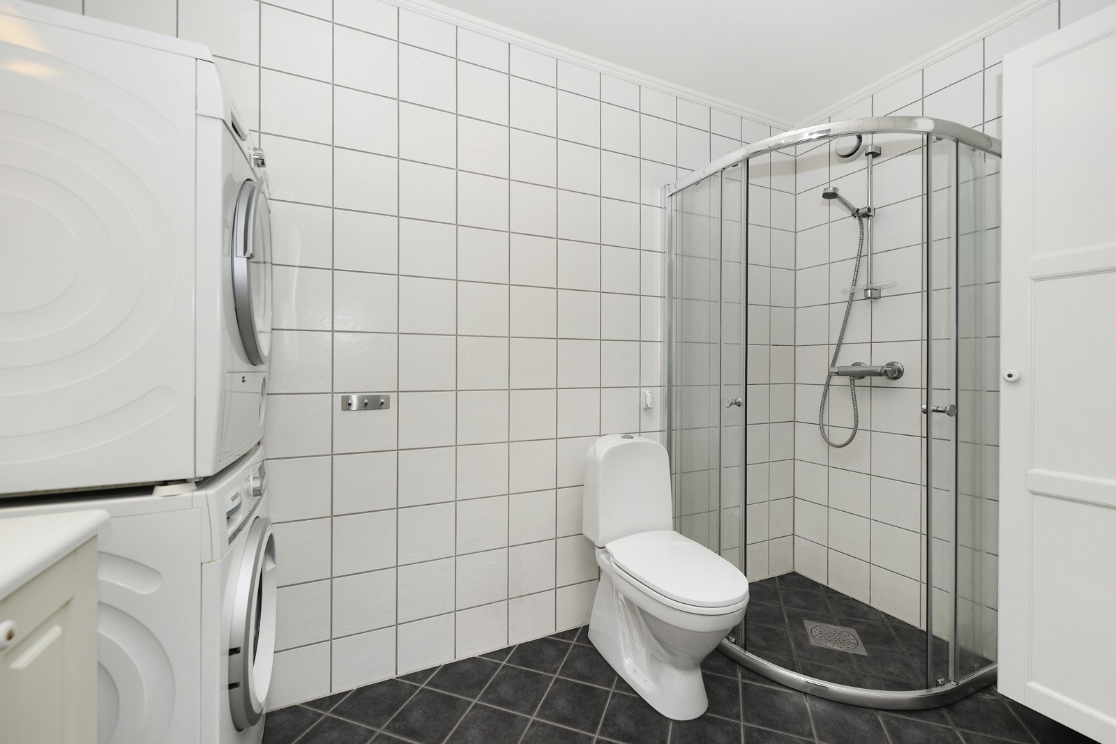 Bad/vaskerommet har flislagt gulv med elektriske varmekabler, flis på vegger og malt tak. Galleribilde