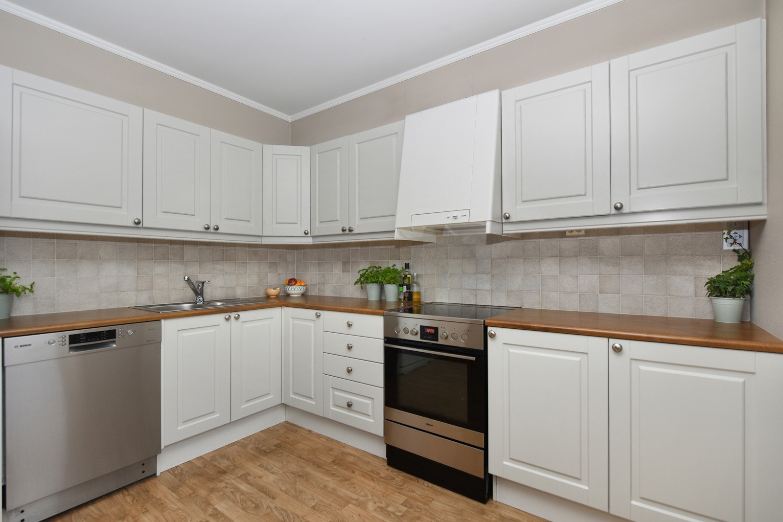 Kjøkkenet er fra byggeår og har pen, hvitprofilert kjøkkeninnredning og laminat benkeplate. Galleribilde