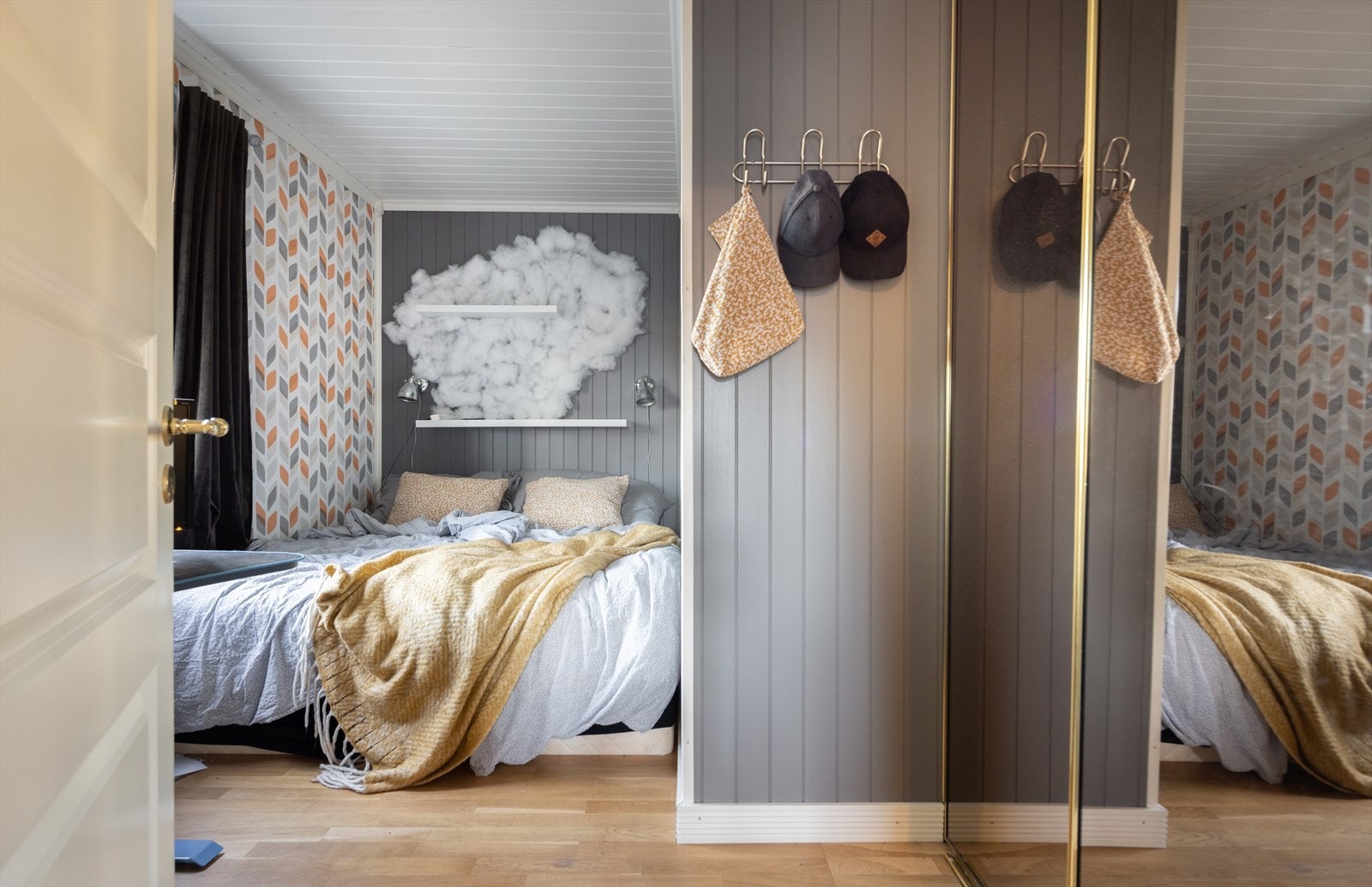 I første etasje finner man også et behagelig soverom med innebygd speilskap med malt veggpanel og malt tak som resten av huset, men her inne har man dessuten en festlig tapetsert vegg. Galleribilde