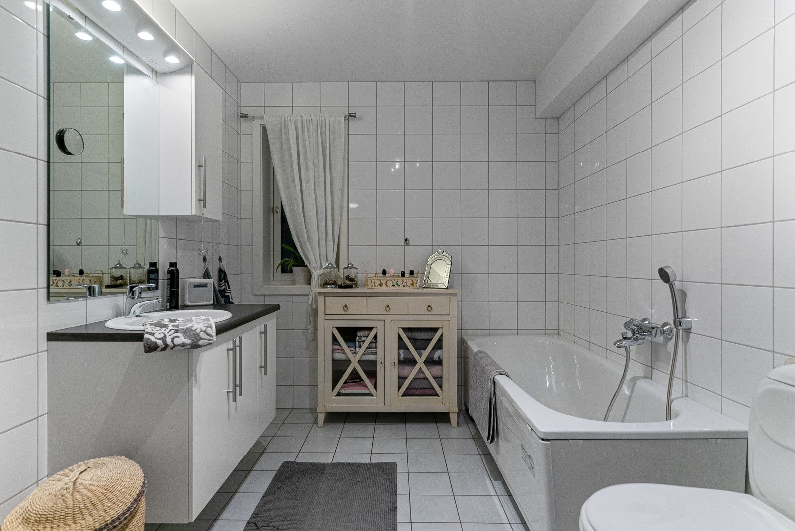 Flott, flislagt bad 7,5 m² med varmekabler i gulv, badekar og dusjhjørne med innfellbare dusjdører Galleribilde