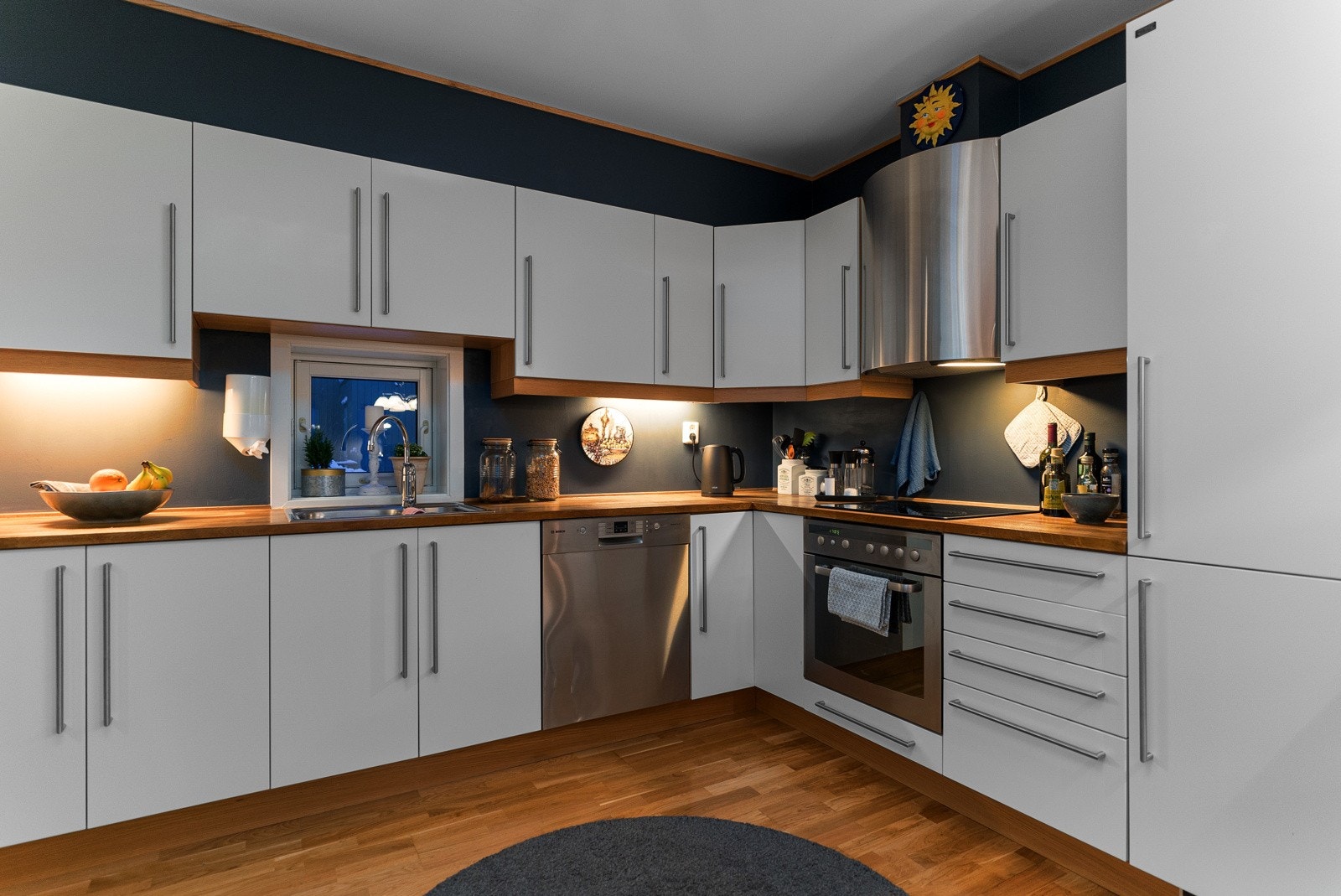 Flott kjøkken fra byggeår med integrerte hvitevarer og praktisk utforming for ekstra god skap- og benkeplass Galleribilde