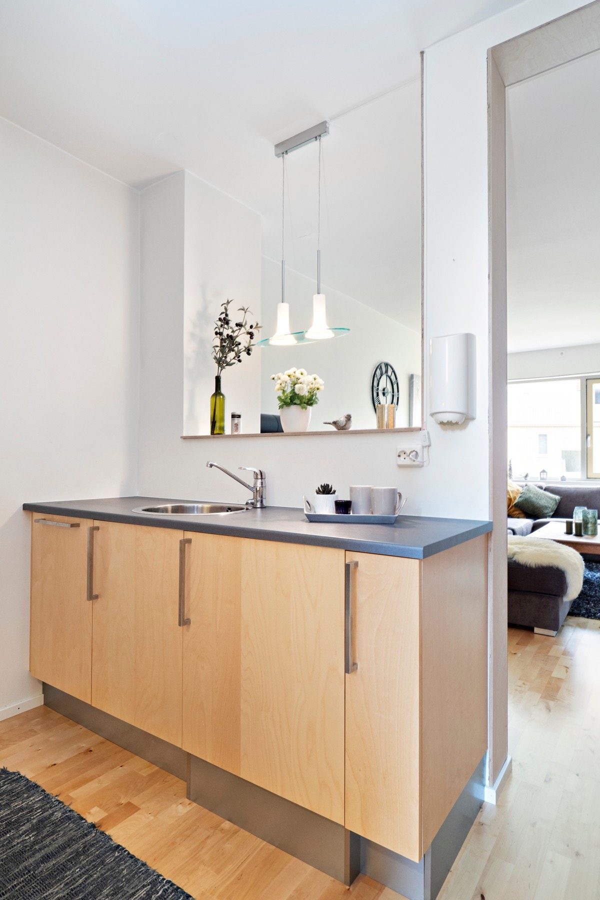 Innredningen har slette fronter i lyst tre og mørke laminatbenkeplater. Stekeovn, koketopp og oppvaskmaskin er integrert. Galleribilde