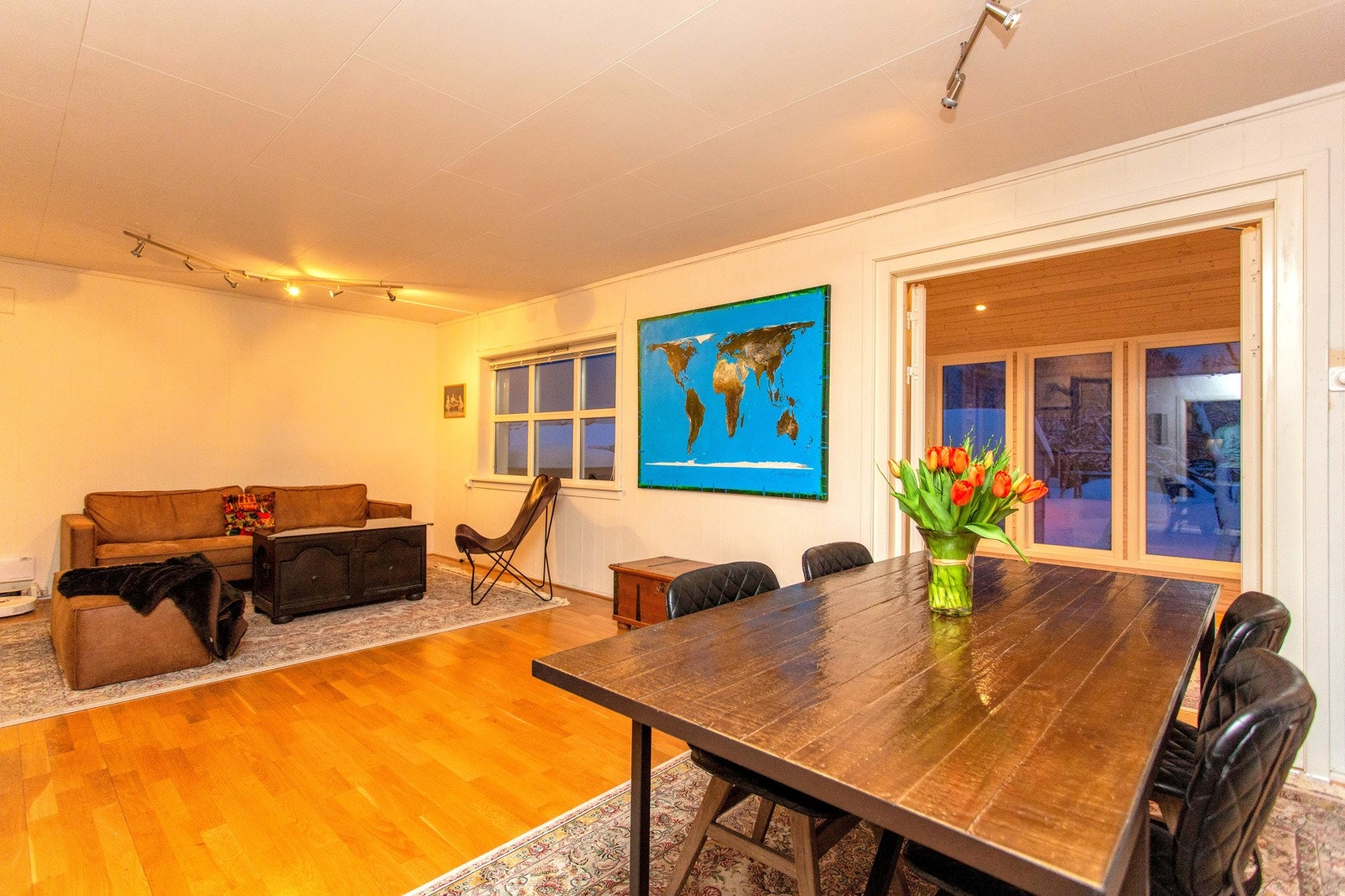 Romslig stue med parkett på gulvet Galleribilde