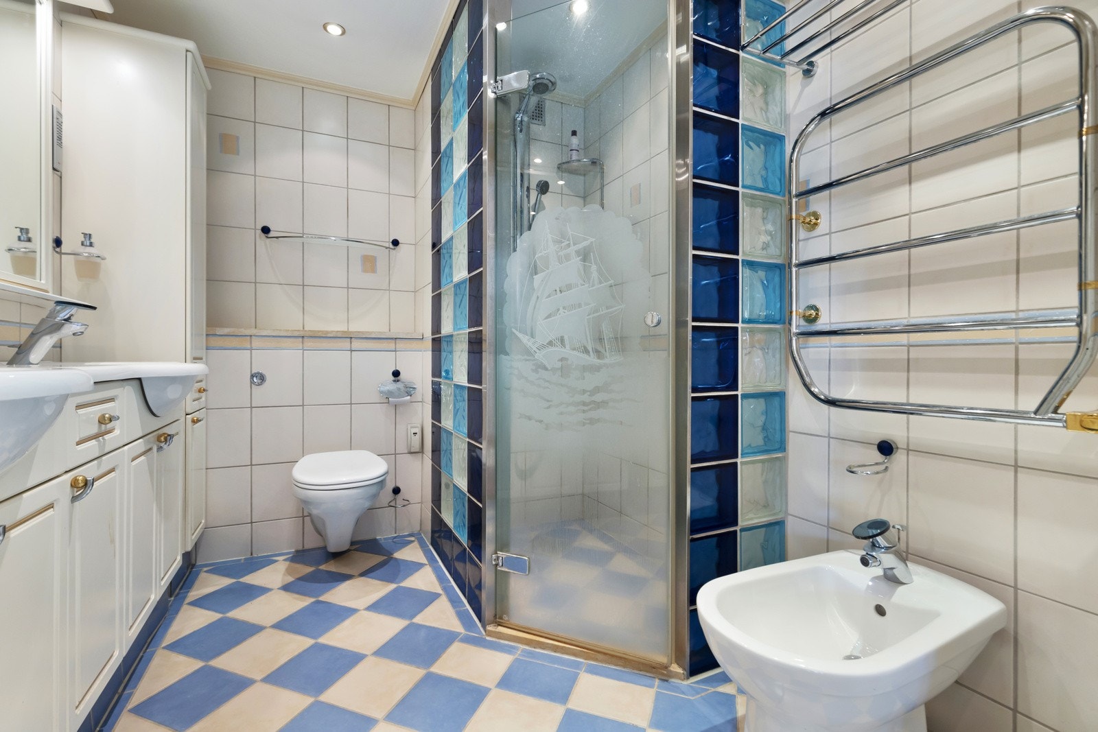 Badet består av dusjhjørne m/ farget glassbyggestein med innfellbar glassdør, vegghengt toalet og innredning underskap og sideskap. Galleribilde