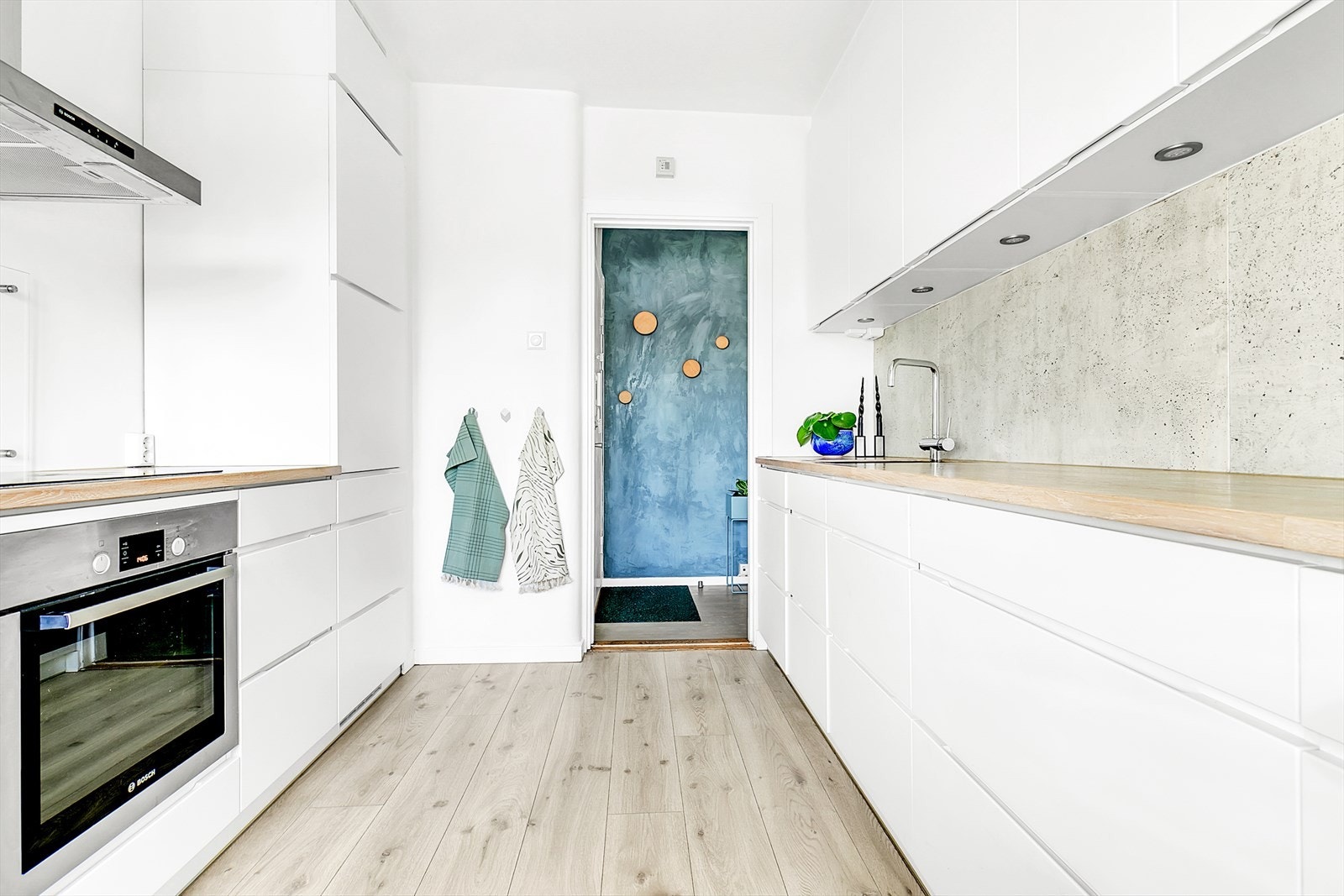 Kjøkkenet er utstyrt med heltre benkeplate med underlimt kum i komposittmateriale, veggmontert ventilator i stål, induksjonstopp, stekeovn, oppvaskmaskin og kjøl/frys er integrert i innredningen. Galleribilde