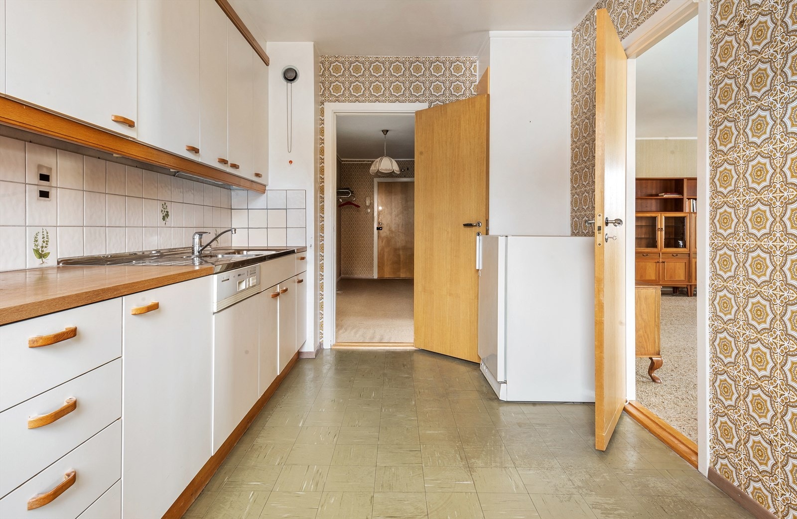 Benkeplate med nedfelt keramisk platetopp. Fliser over benk. Integrert stekeovn og oppvaskmaskin. Waterguard under benk. Galleribilde